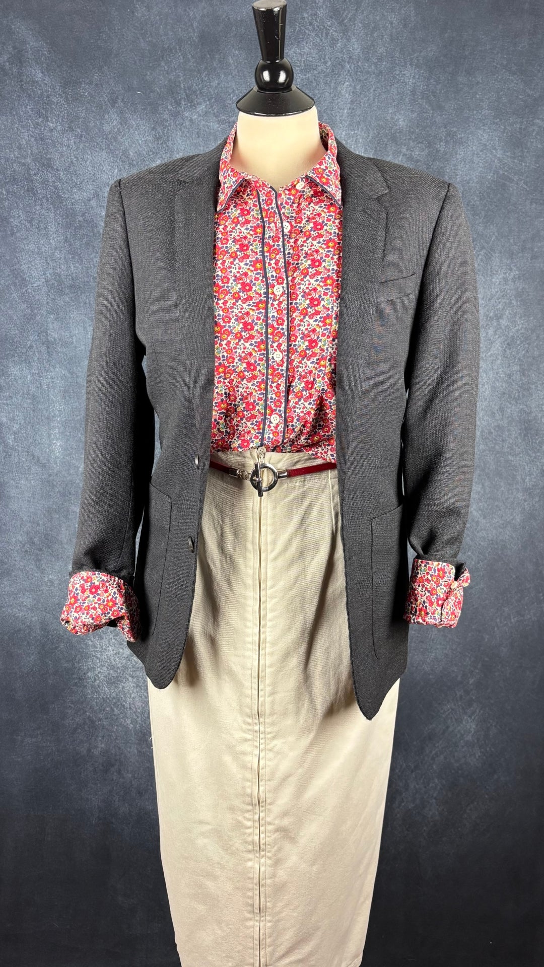 Blazer en laine gris foncé légèrement bleuté, Sandro taille estimée à small. Vue de l'agencement avec la ceinture en cuir rouge, le chemisier floral Liberty J.Crew et la jupe crème Harly Jae.