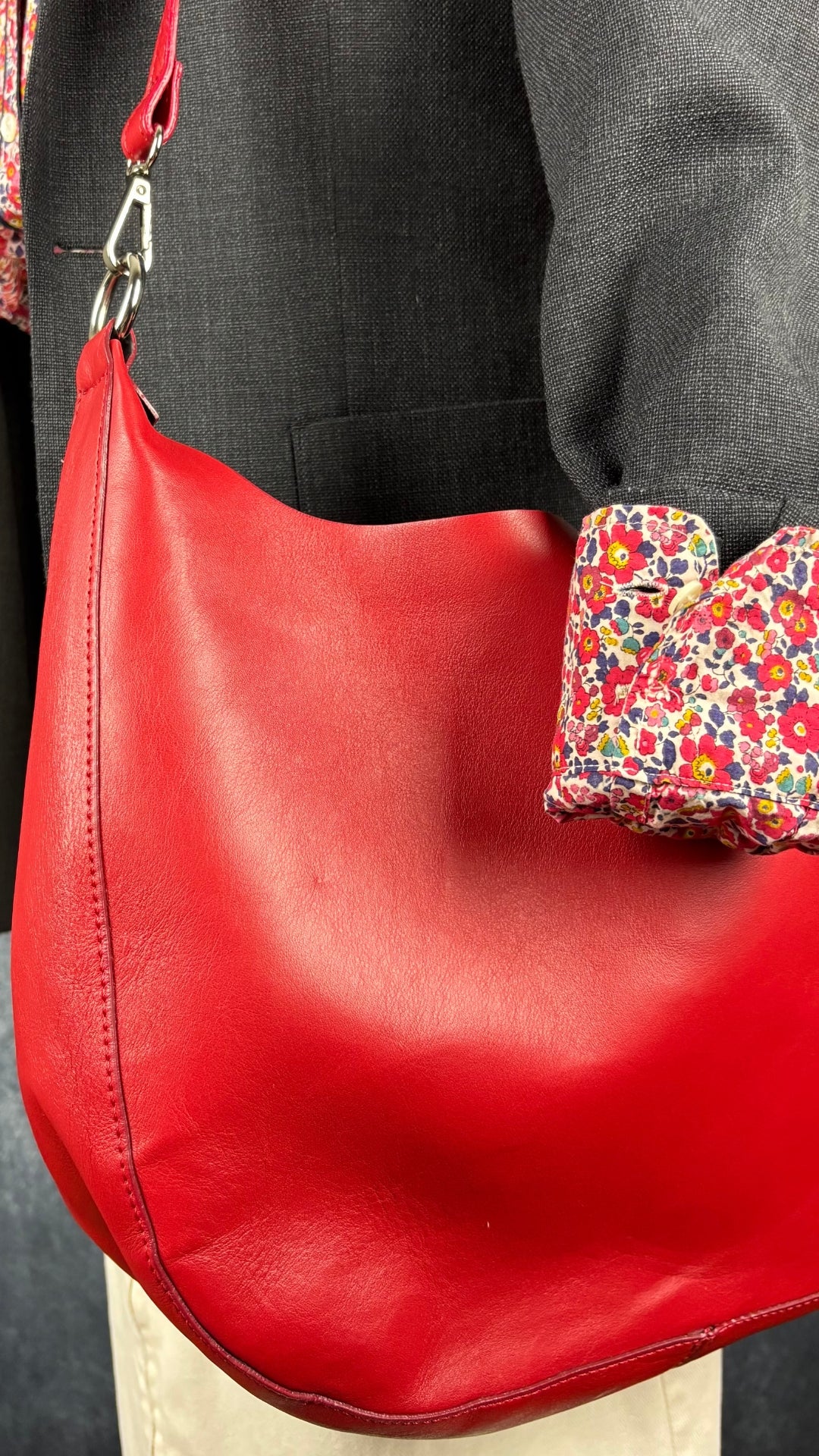 Blazer en laine gris foncé légèrement bleuté, Sandro taille estimée à small. Vue de près des détails de la veste, du sac à main rouge, du chemisier floral et de la jupe Harly Jae.