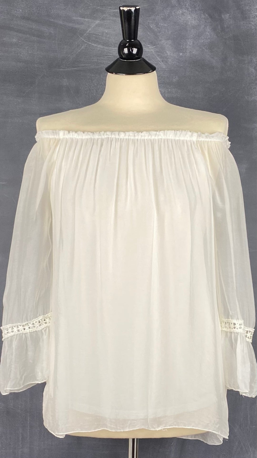 Blouse de type doll blouse vaporeuse de couleur crème en mélange de soie et viscose. Marque Bellaambra, taille small. Vue de face, deux épaules dégagées.