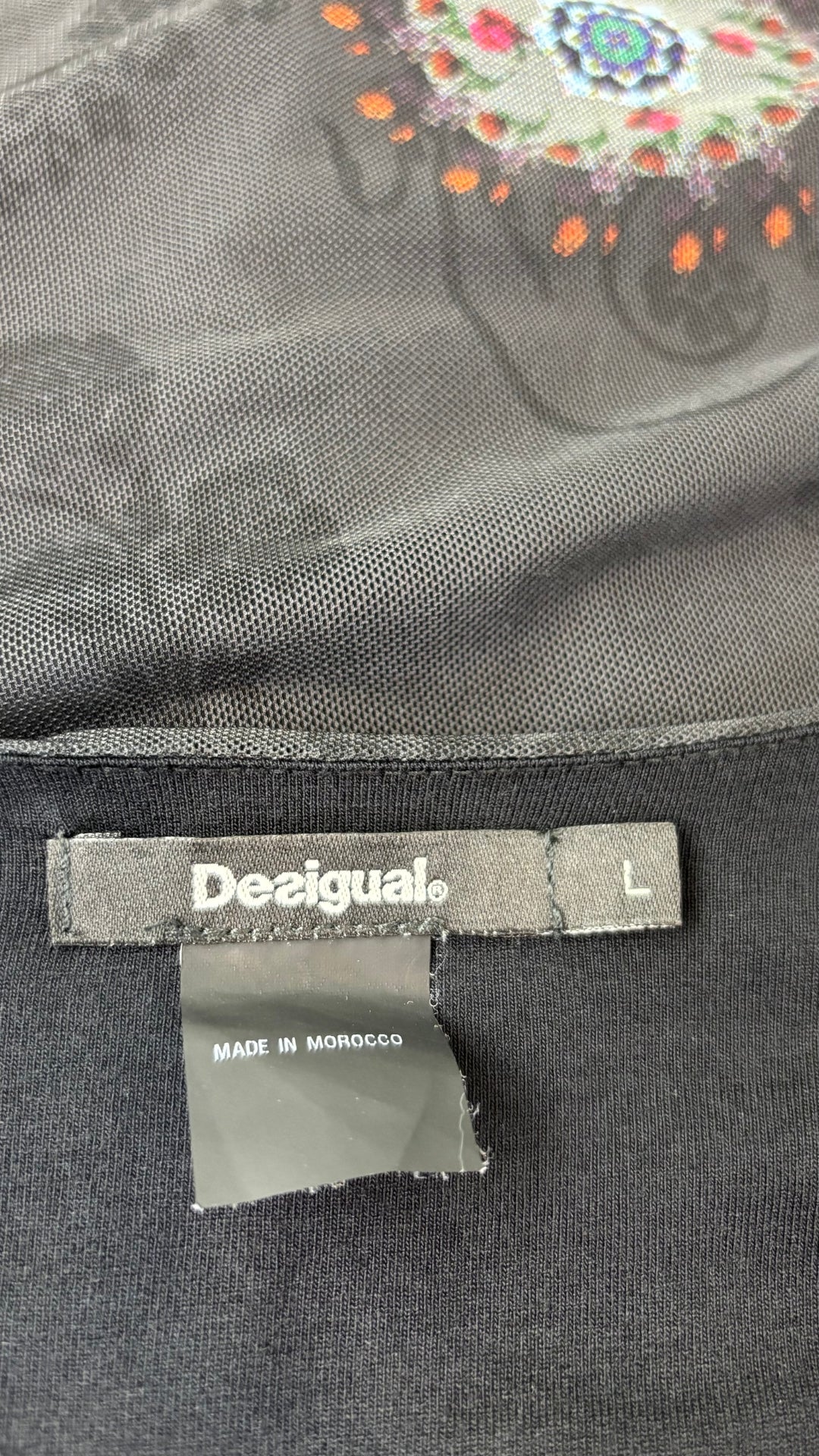 Blouse noire en fin voilage à jolis motifs Desigual, taille large (m/l). Vue de l'étiquette.