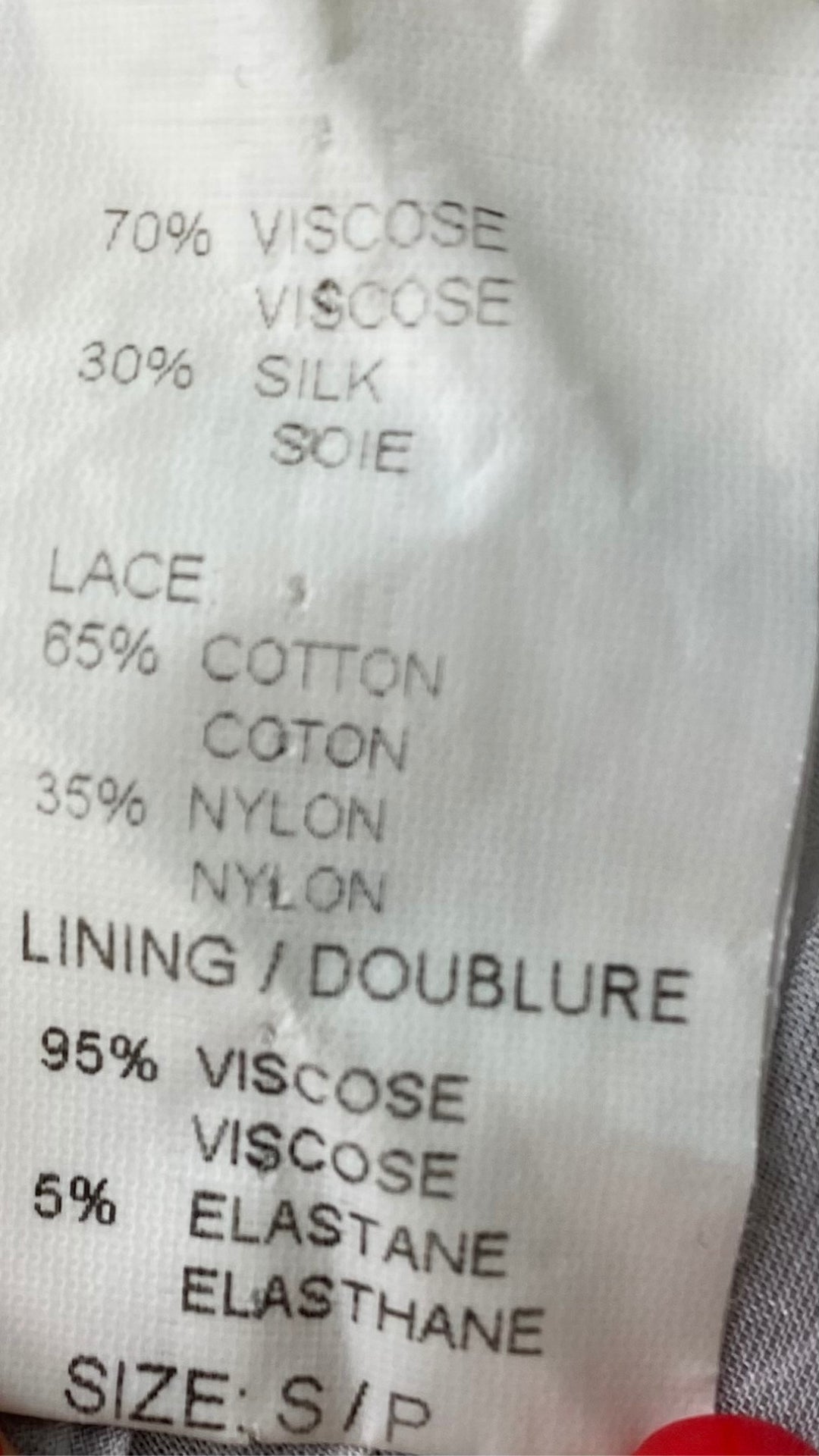 Blouse vaporeuse crème et greige mélange de soie avec broderie, taille small. Vue de l'étiquette de composition.
