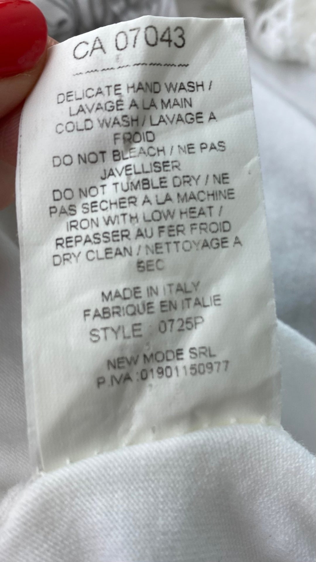 Blouse vaporeuse crème et greige mélange de soie avec broderie, taille small. Vue de l'étiquette d'entretien.
