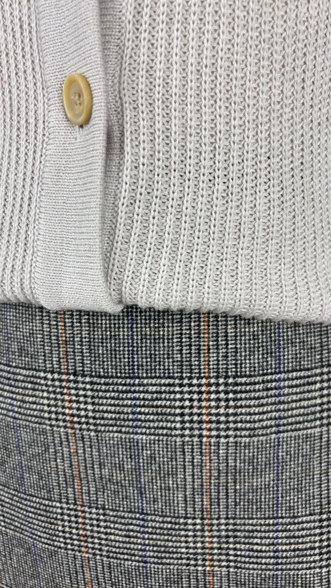 Cardigan gris beige en coton et cachemire Ça va de soi, taille small. Vue de près de l'agencement avec la jupe à carreaux Wilfred.