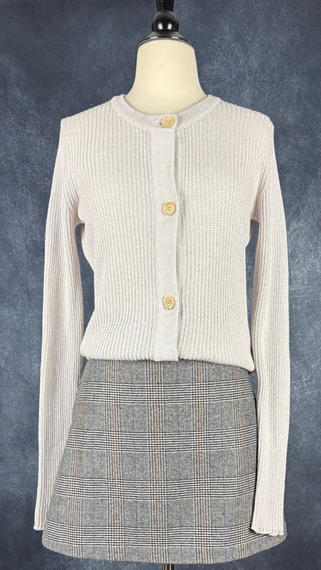 Cardigan gris beige en coton et cachemire Ça va de soi, taille small. Vue de l'agencement avec la jupe à carreaux prince de Galles Wilfred.
