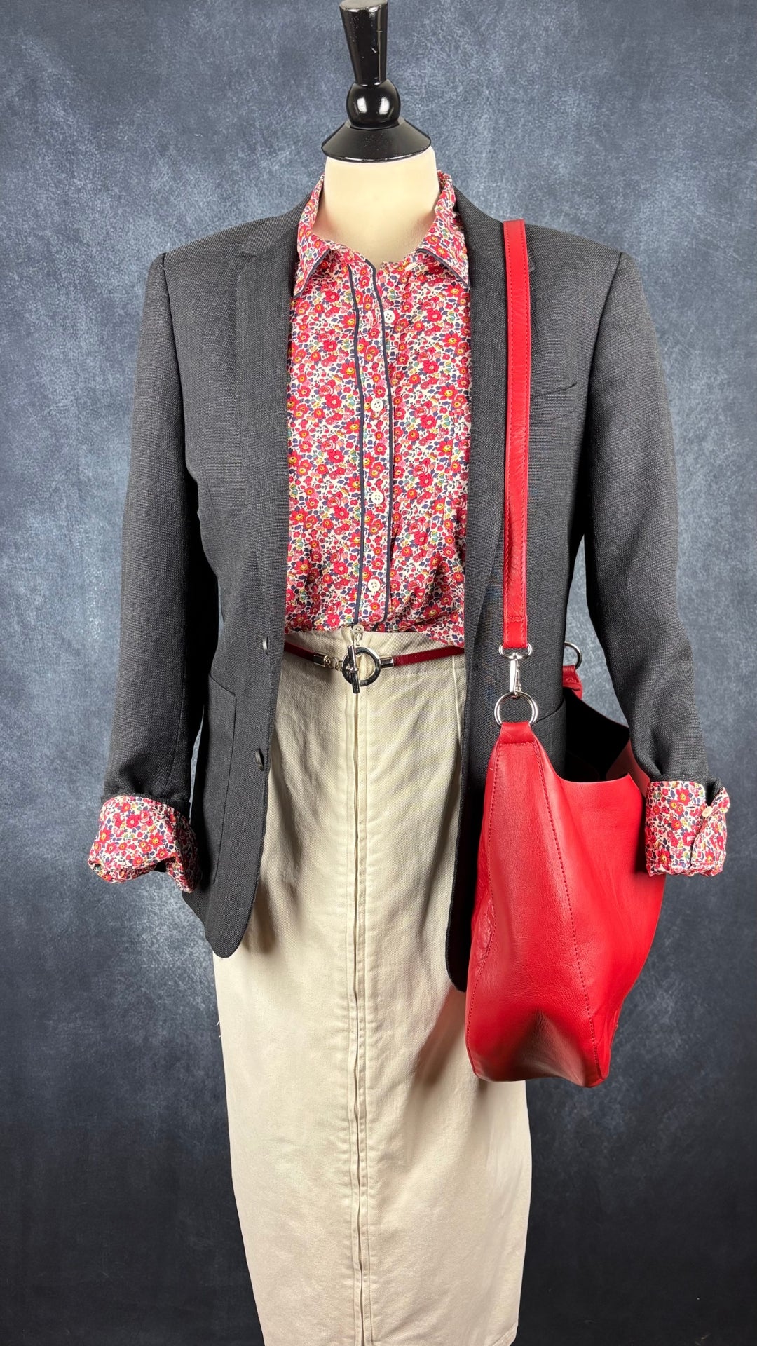 Ceinture en cuir rouge taille unique. Vue de l'agencement avec la jupe crème, le chemisier floral Liberty, le blazer Sandro et le sac à main en cuir rouge.