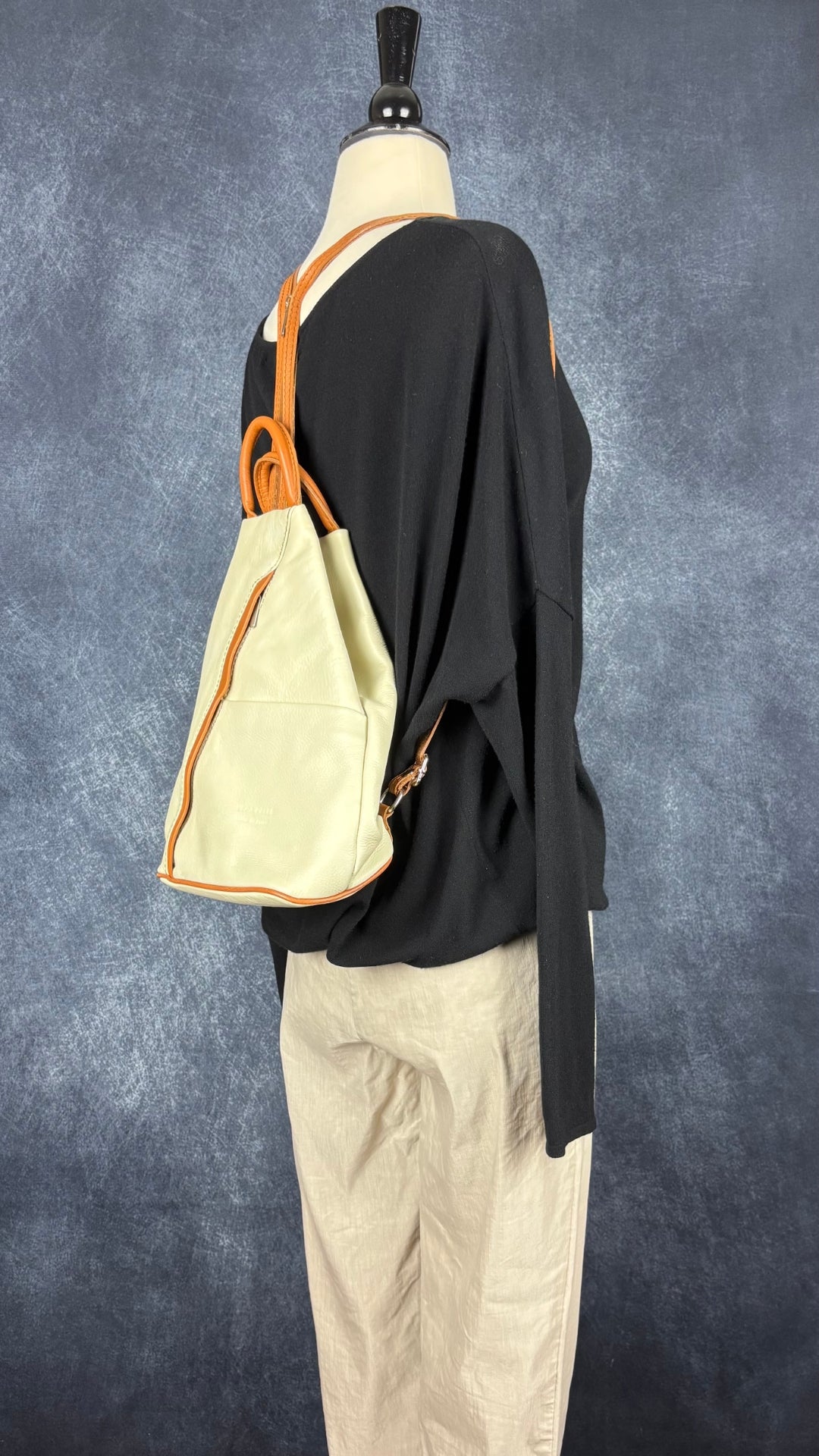 Sac à dos en cuir souple beige crème et brun tan Vera Pelle, fabriqué en Italie. Vue de l'agencement avec le pantalon et le chandail Sarah Pacini.