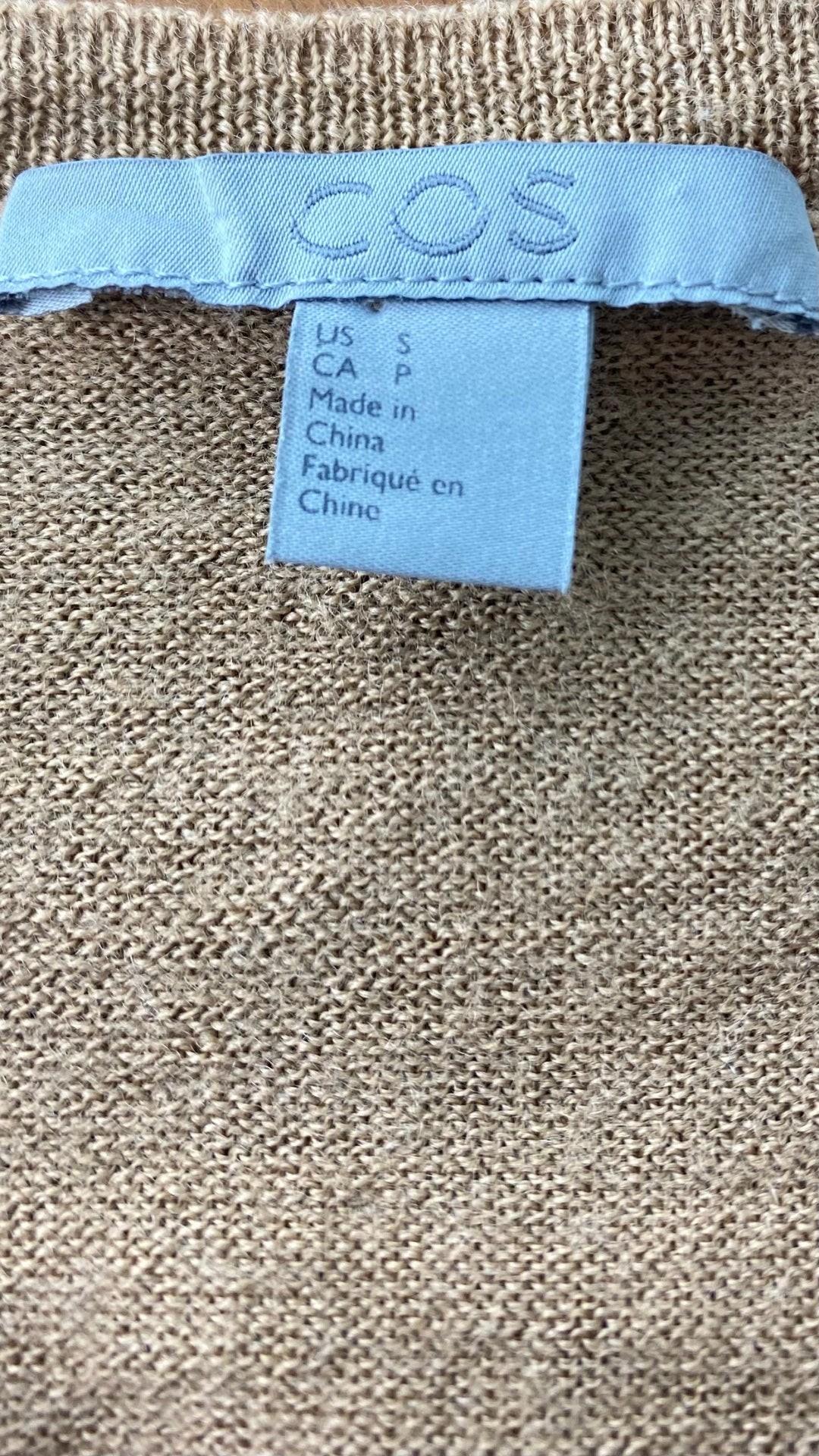 Chandail ample en tricot mince chameau à col en v Cos, taille small. Vue de l'étiquette de marque et taille.