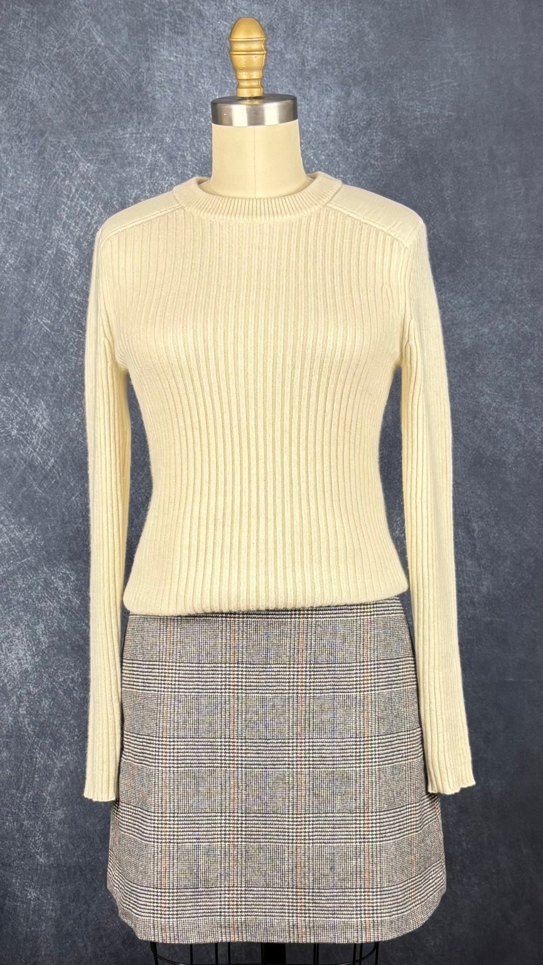 Chandail crème en tricot de cachemire Club Monaco, taille small. Vue de l'agencement avec la jupe à carrreaux Wilfred.