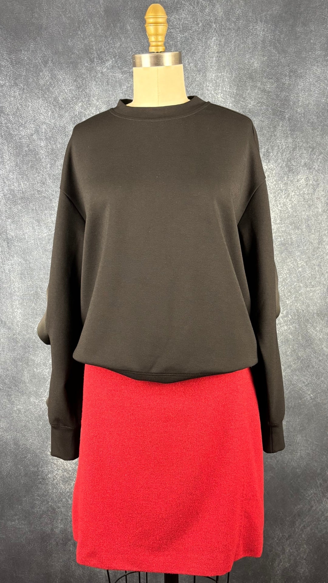 Chandail noir à col rond coupe ample et manches à volants Yaya Women, taille small. Vue de l'agencement avec la jupe en lainage rouge Weekend MaxMara.