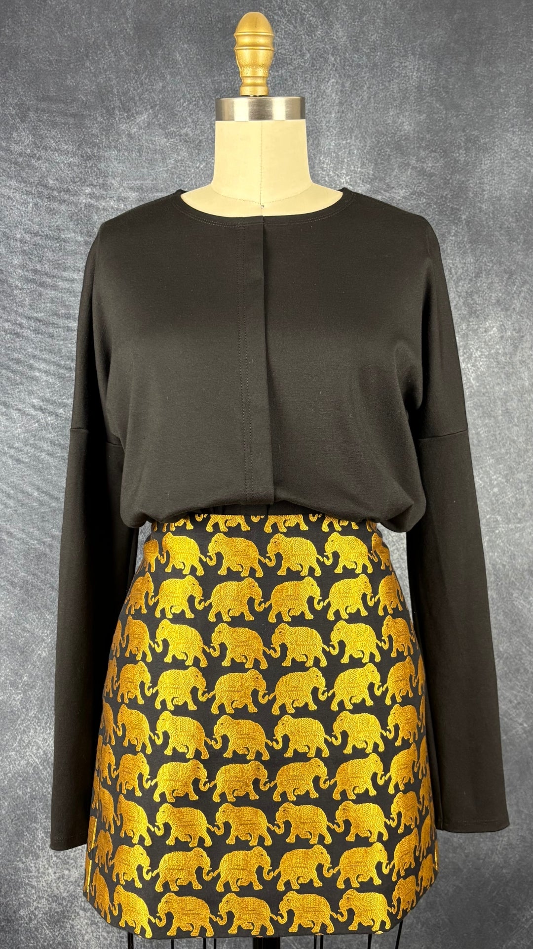 Chandail noir style chemisier Elisa C-Rossow, taille small. Vue de l'agencement avec la jupe à motifs d'éléphants J.Crew.