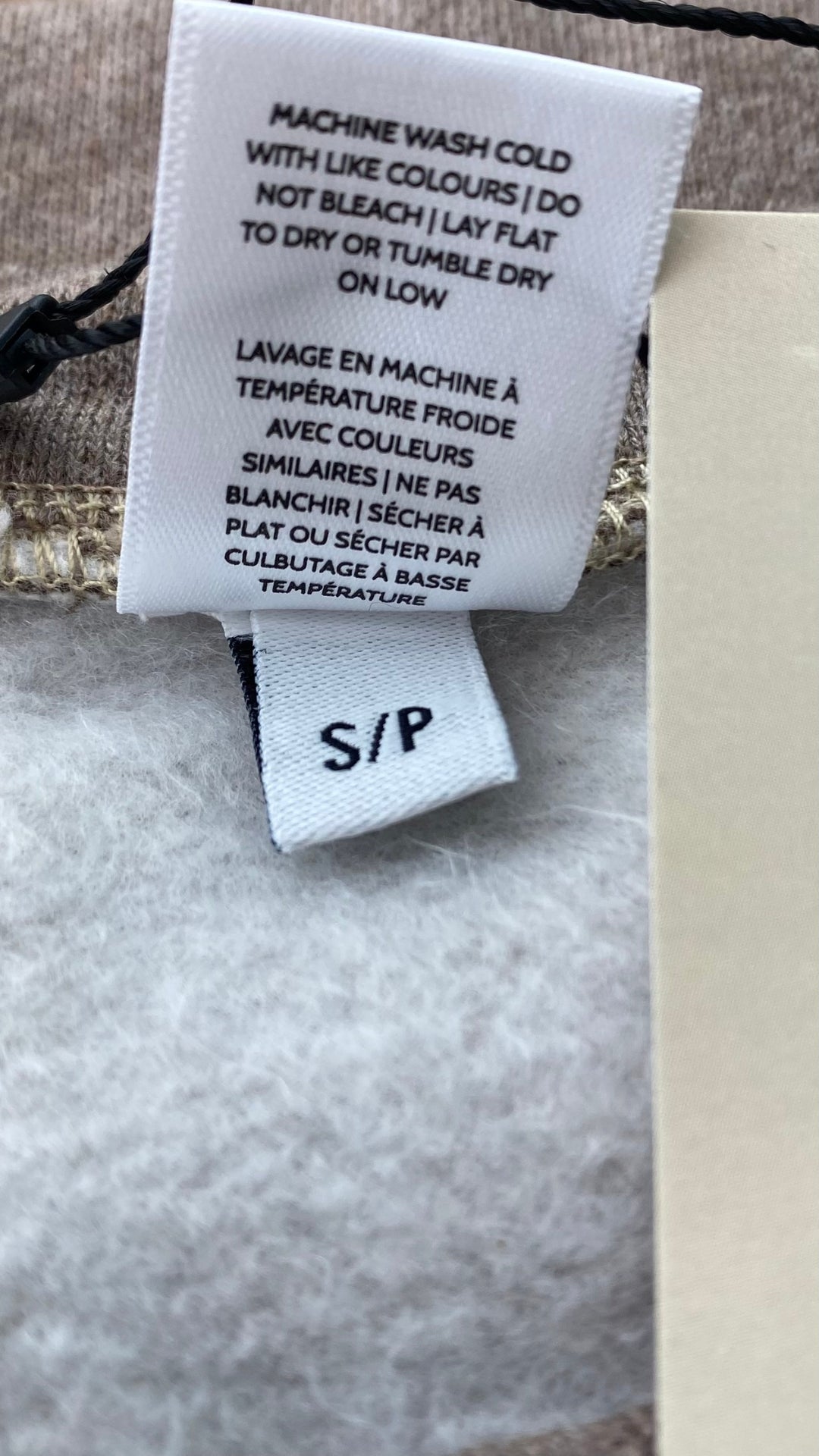 Chandail ouaté col rond confort suprême, Sève&Co., plusieurs tailles disponibles, 2 couleurs. Vue de l'étiquette d'entretien.