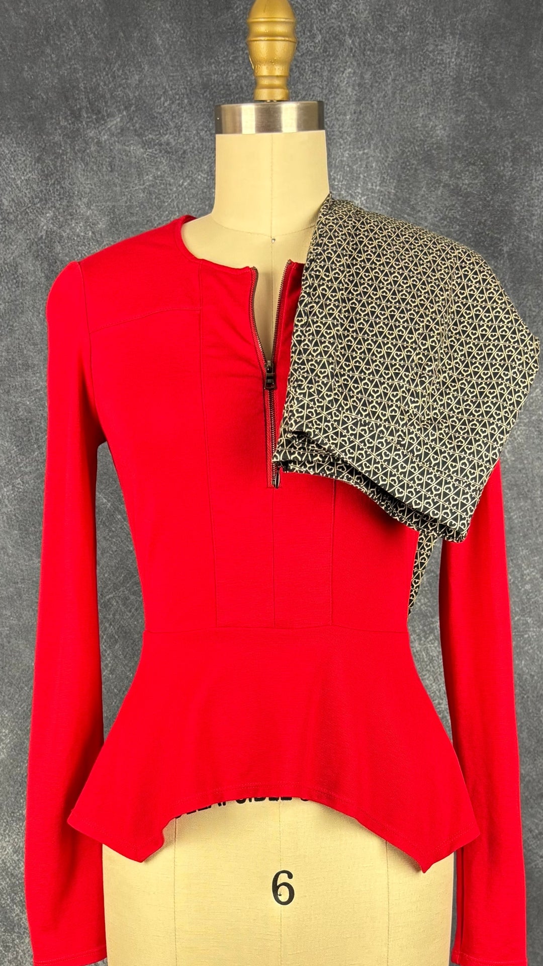 Chandail rouge en ponte à ourlet péplum asymétrique BCBG MaxAzria, taille xs. Vue de l'agencement avec le pantalon à motifs Oui.
