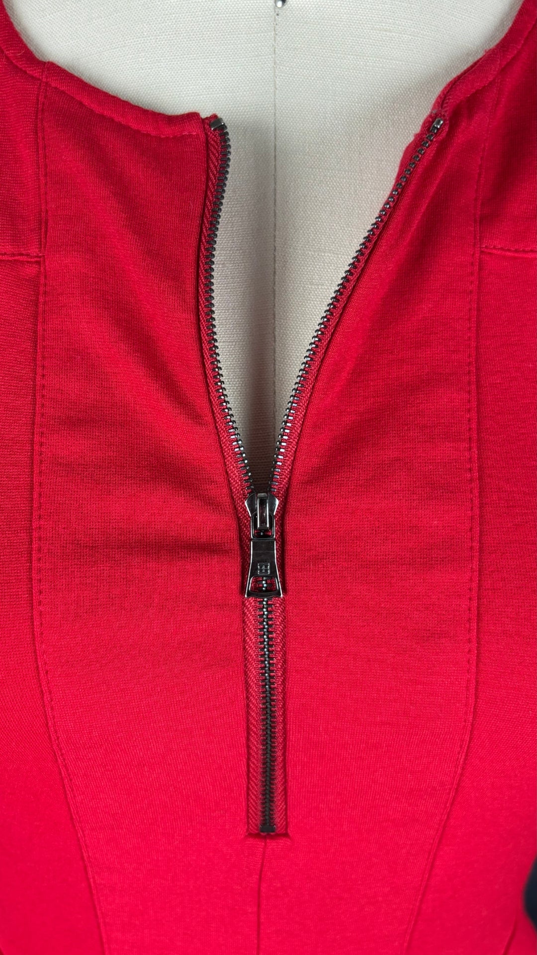 Chandail rouge en ponte à ourlet péplum asymétrique BCBG MaxAzria, taille xs. Vue de près de la fermeture à glissière.