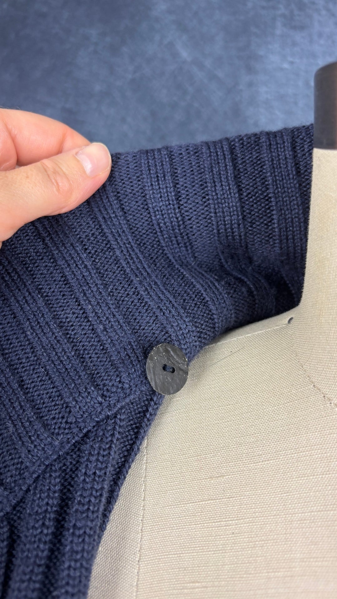 Chandail en tricot asymétrique bleu acier et noir avec fermeture à glissière et col 3 façons Sarah Pacini, xs à medium. Vue de près du bouton intérieur à l'encolure.