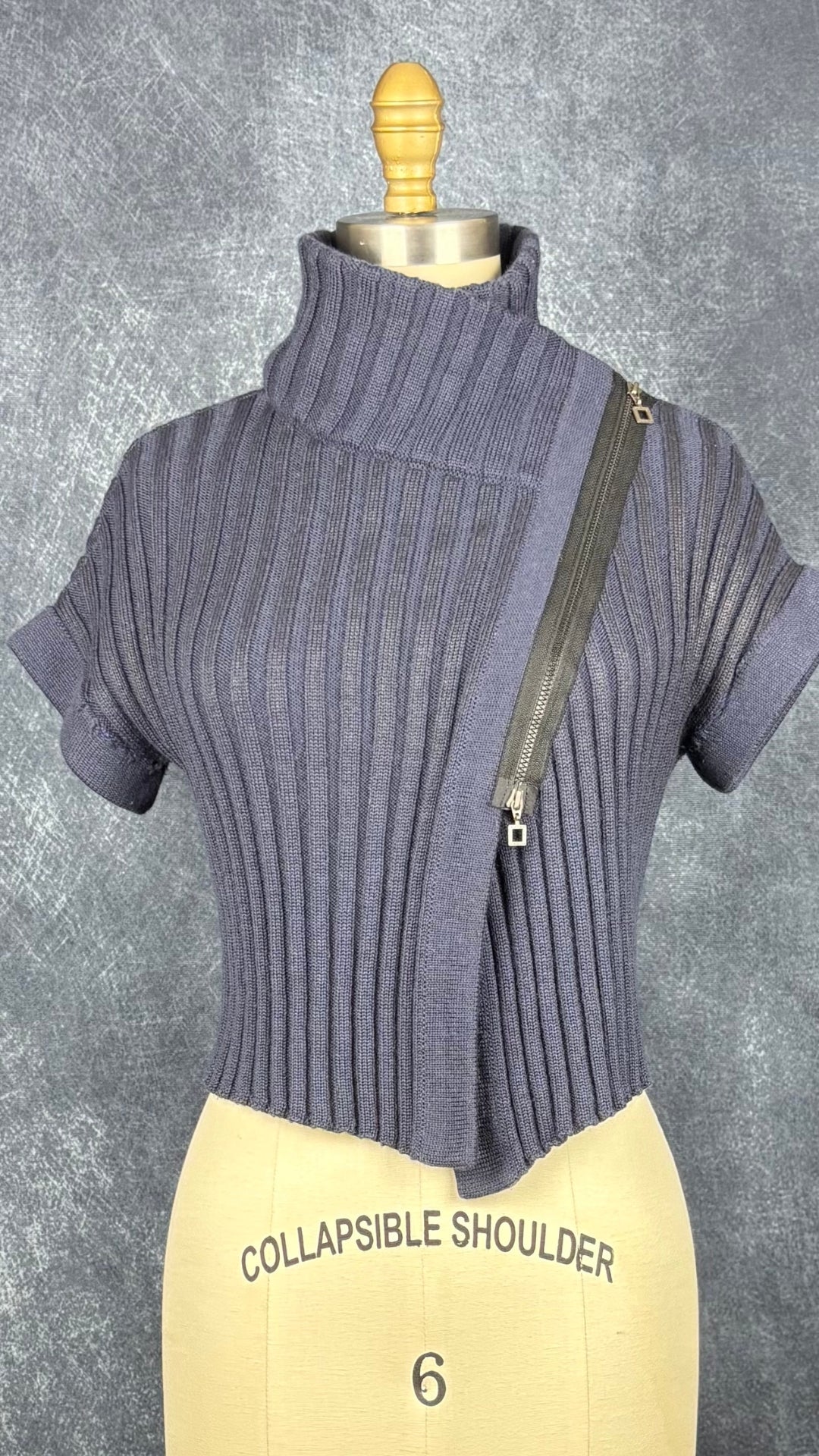 Chandail en tricot asymétrique bleu acier et noir avec fermeture à glissière et col 3 façons Sarah Pacini, xs à medium. Vue de face, col fermé.