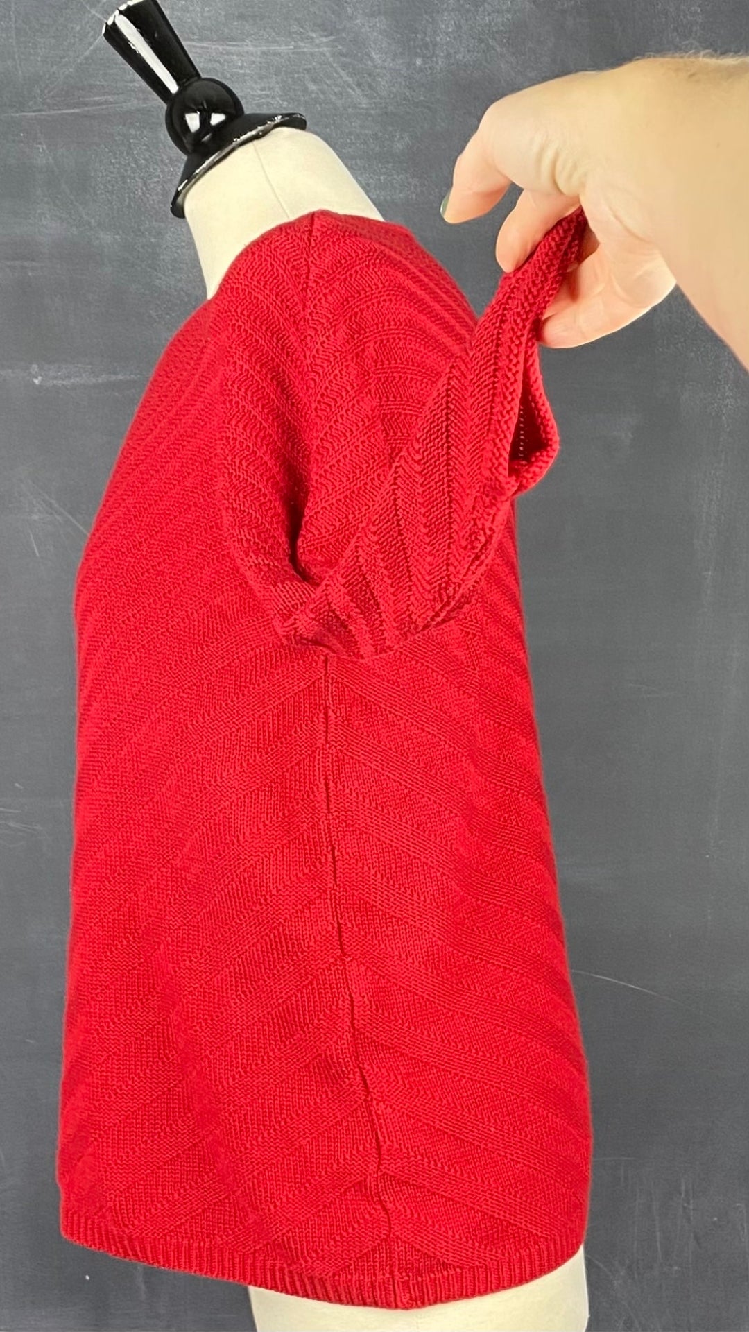 Chandail tricot rouge à chevrons Olsen, taille s-m. Vue de côté, la manche relevée.