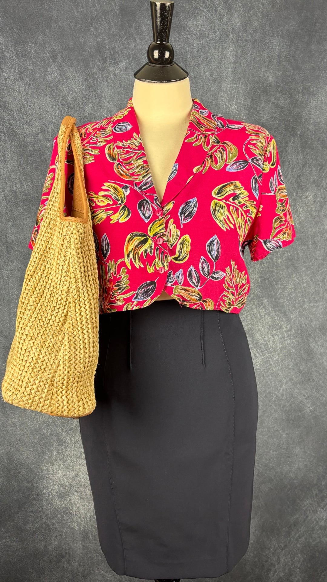 Chemisier court vintage à motifs tropicaux Part Two, taille small. Vue de l'agencement avec la jupe crayon marine Iris Setlakwe et un sac à main estival en paille.