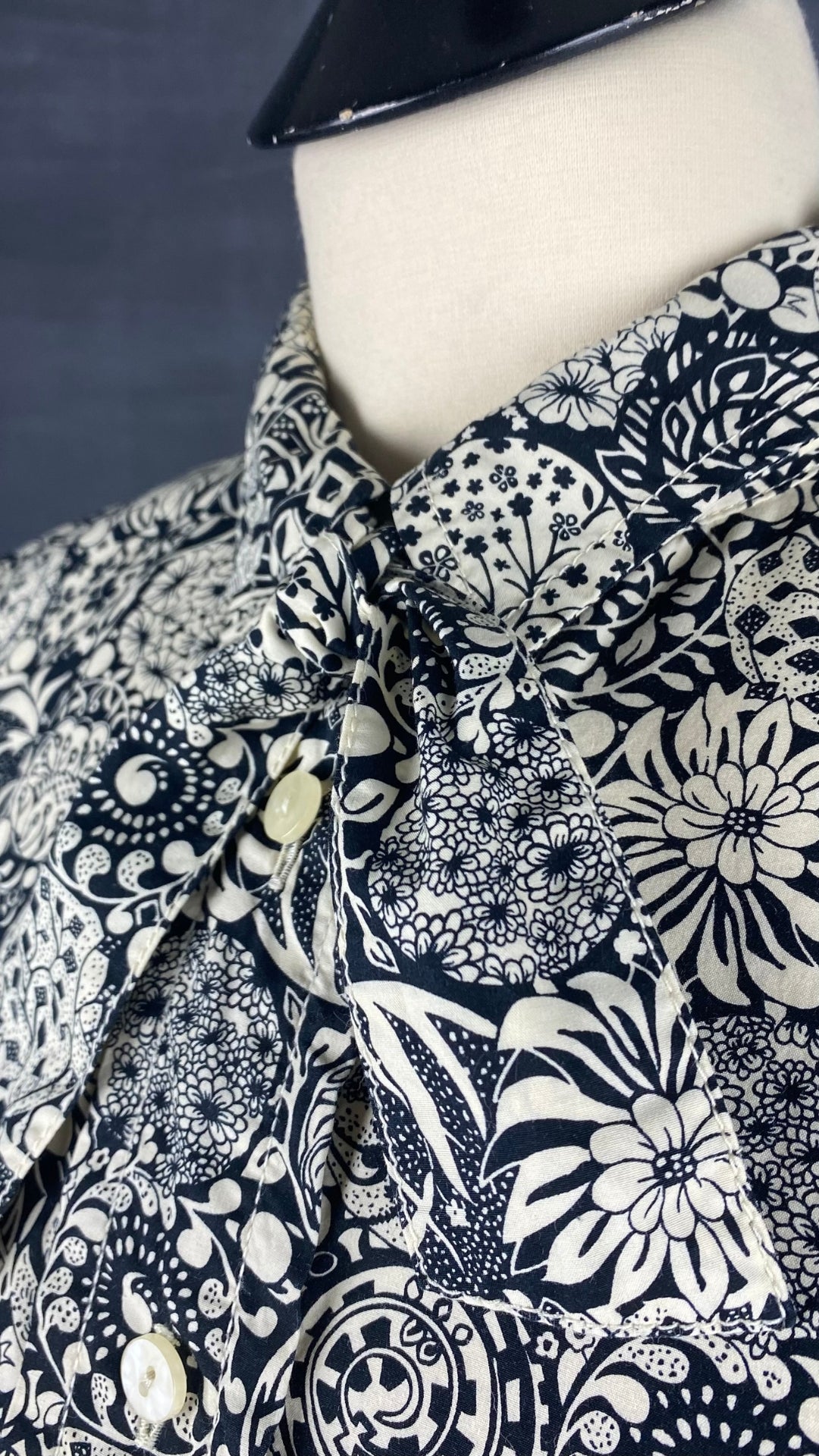 Chemisier noir et crème à motif floral Liz Clairborne taille large. Vue de l'encolure.