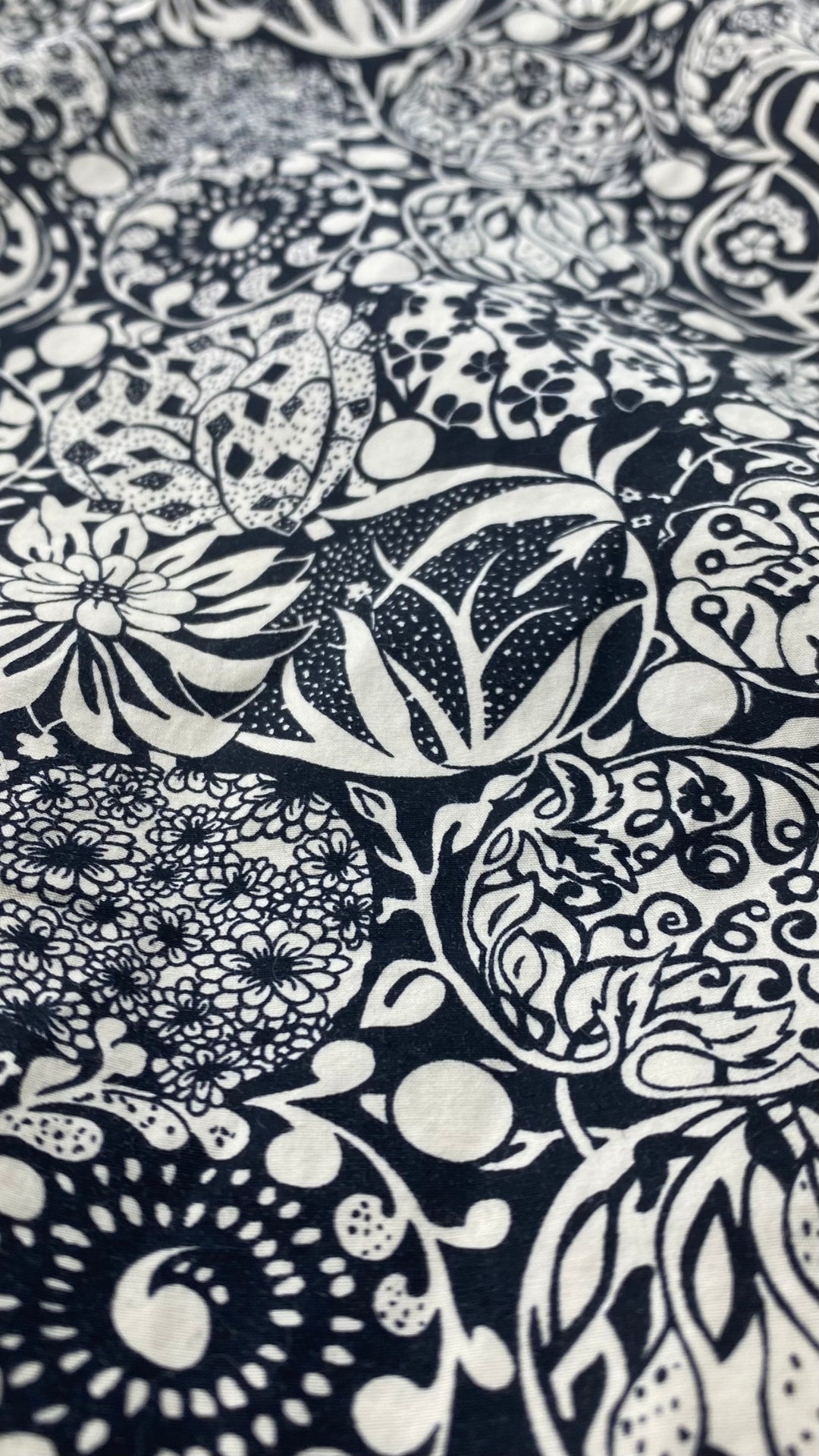 Chemisier noir et crème à motif floral Liz Clairborne taille large. Vue de près du tissu.