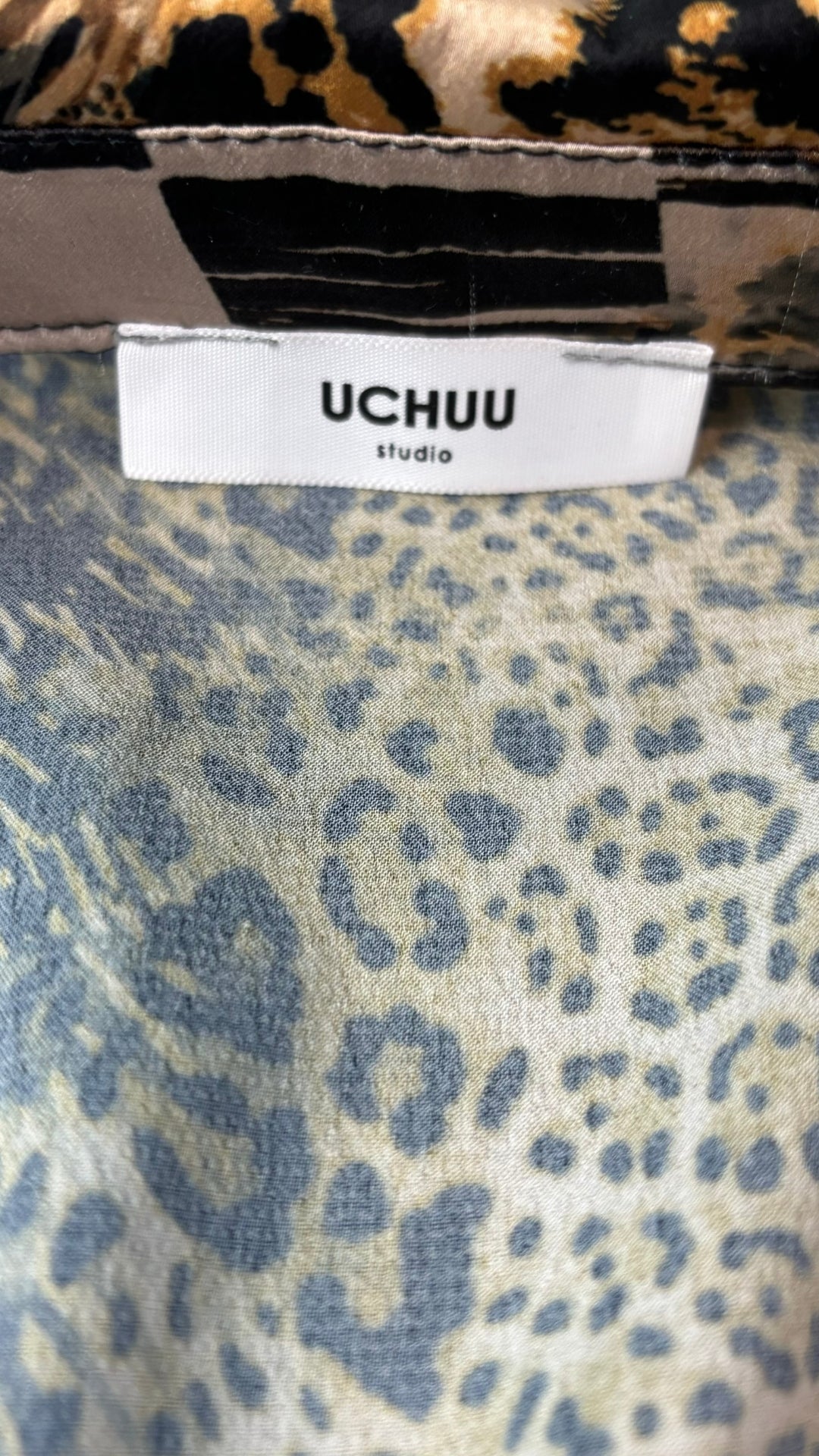 Chemisier tunique léopard Uchuu Studio, taille estimée m/l. Vue de l'étiquette de marque.