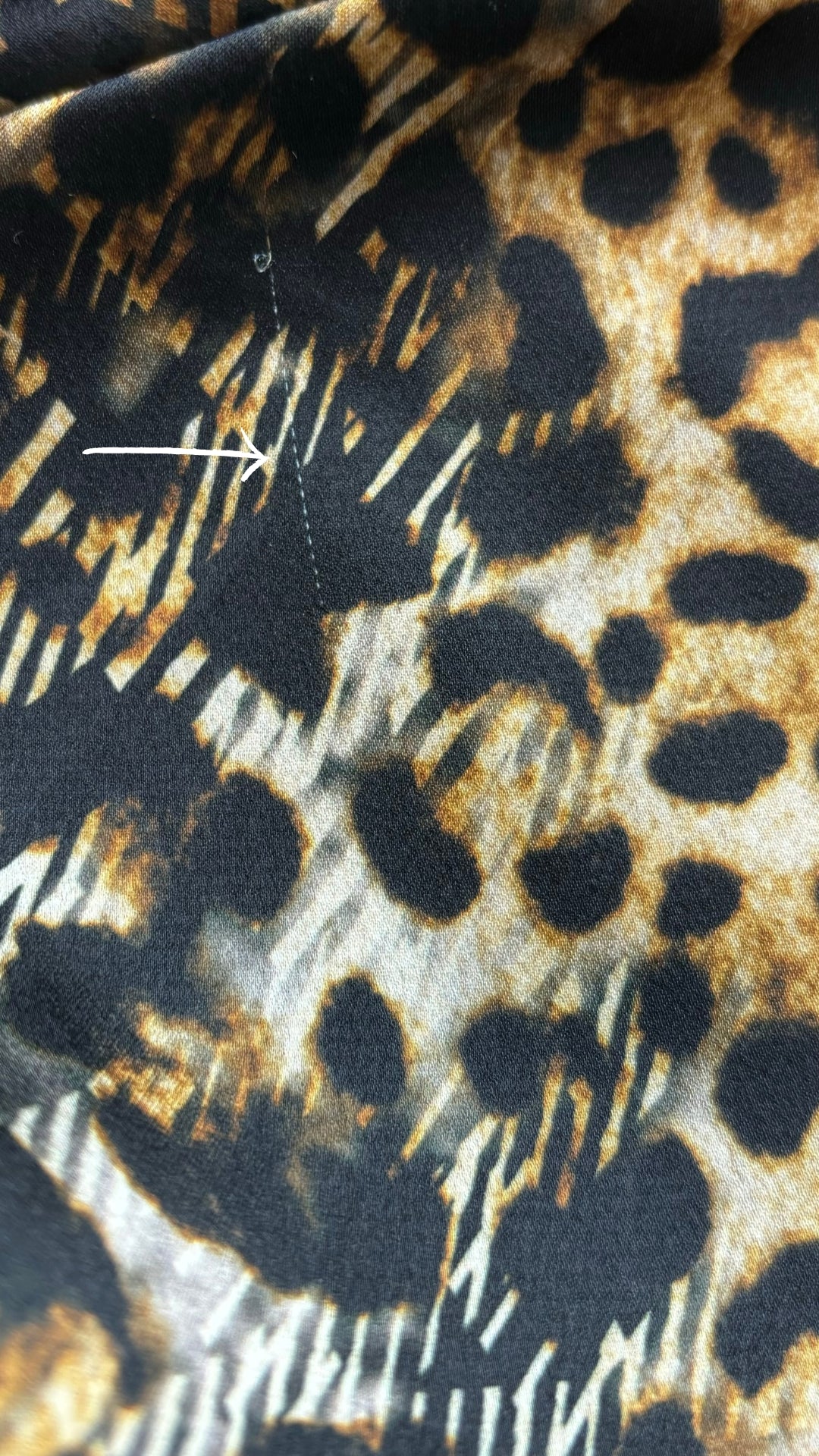 Chemisier tunique léopard Uchuu Studio, taille estimée m/l. Vue d'une petite ligne dans le tissu.