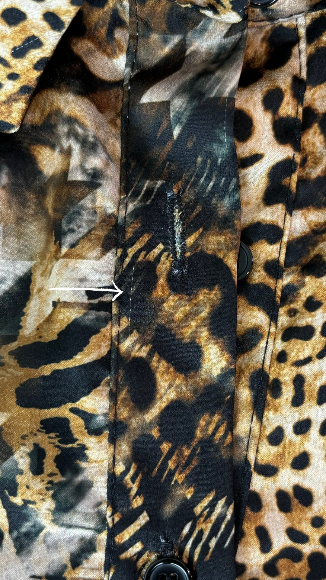 Chemisier tunique léopard Uchuu Studio, taille estimée m/l. Vue de la petite ligne dans le tissu près de la boutonnière.