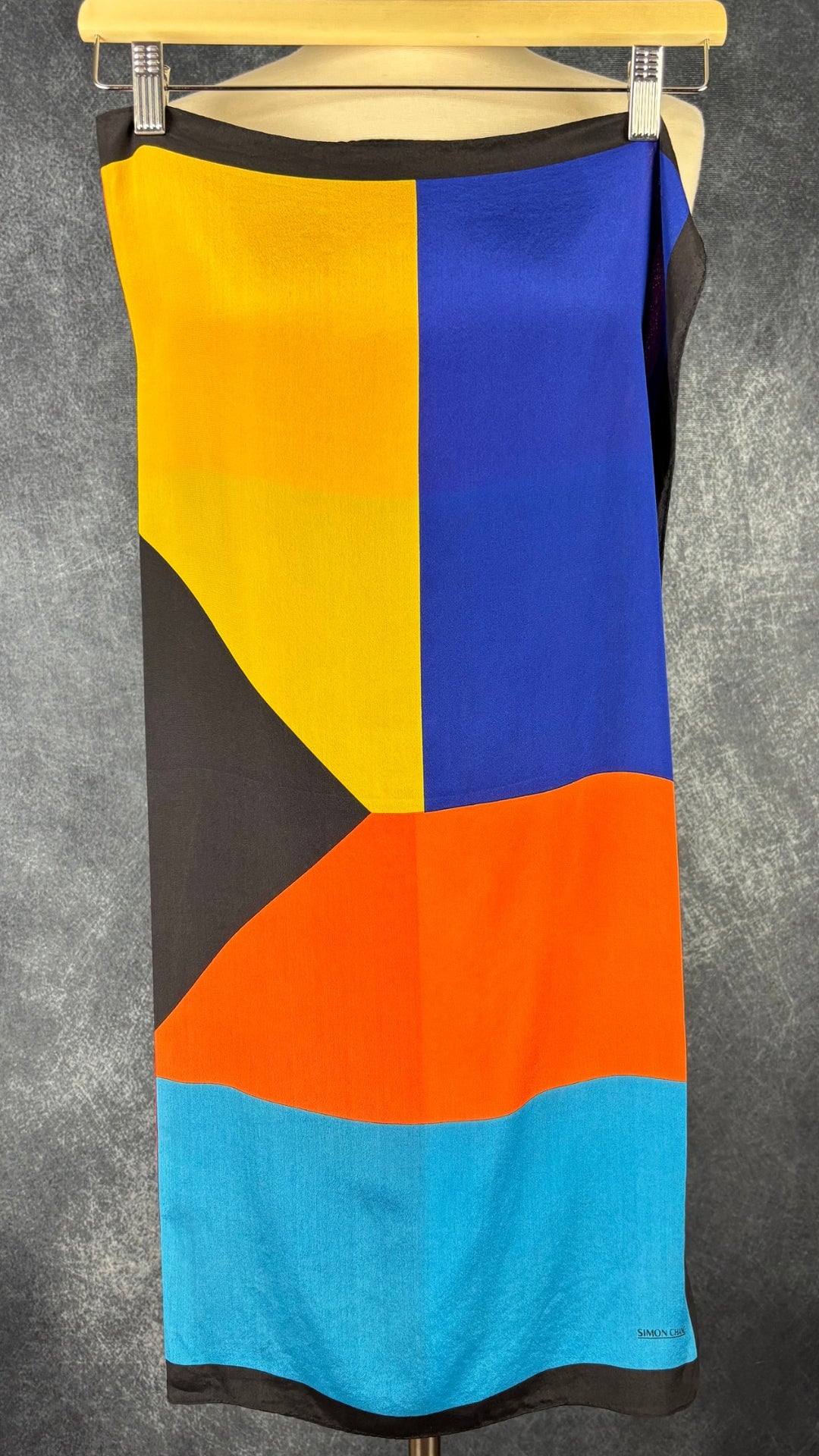 Foulard coloré à motifs géo Simon Chang, format carré. Vue du foulard plié en deux, de l'autre côté.