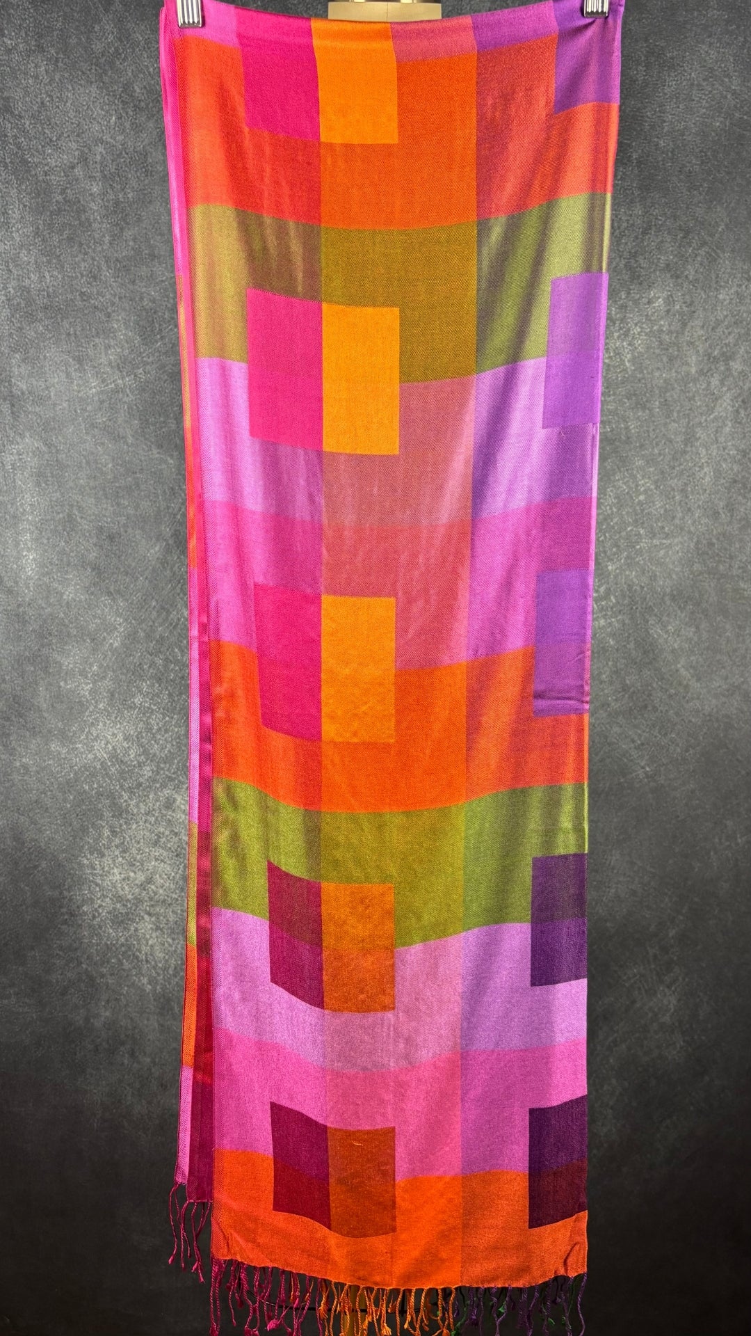 Grand foulard rectangulaire en twill de soie colorée. Vue de face, plié en 4 sur un cintre.
