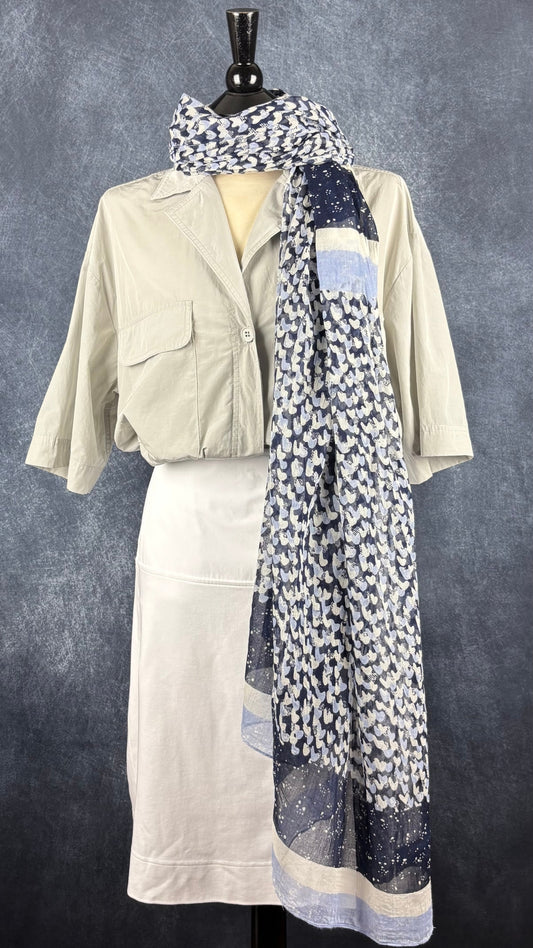 Foulard à petits motifs qui ressemblent à des coeurs gris, bleu doux, marine, Sandwich, grand rectangle. Vue de l'agencement avec la jupe blanche Saint James et le chemisier gris The Group Babaton.