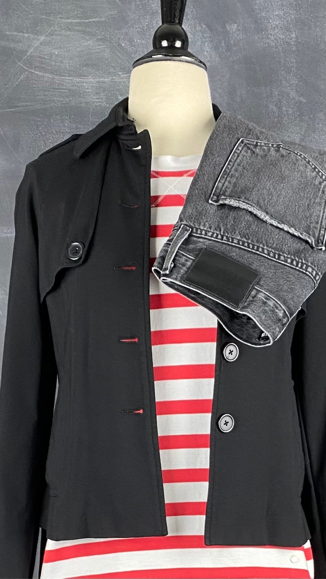 Jeans noir délavé à jambe étroite Agolde x Talula, taille 23. Vue de l'agencement avec le chandail à rayures rouges et la veste style trench.