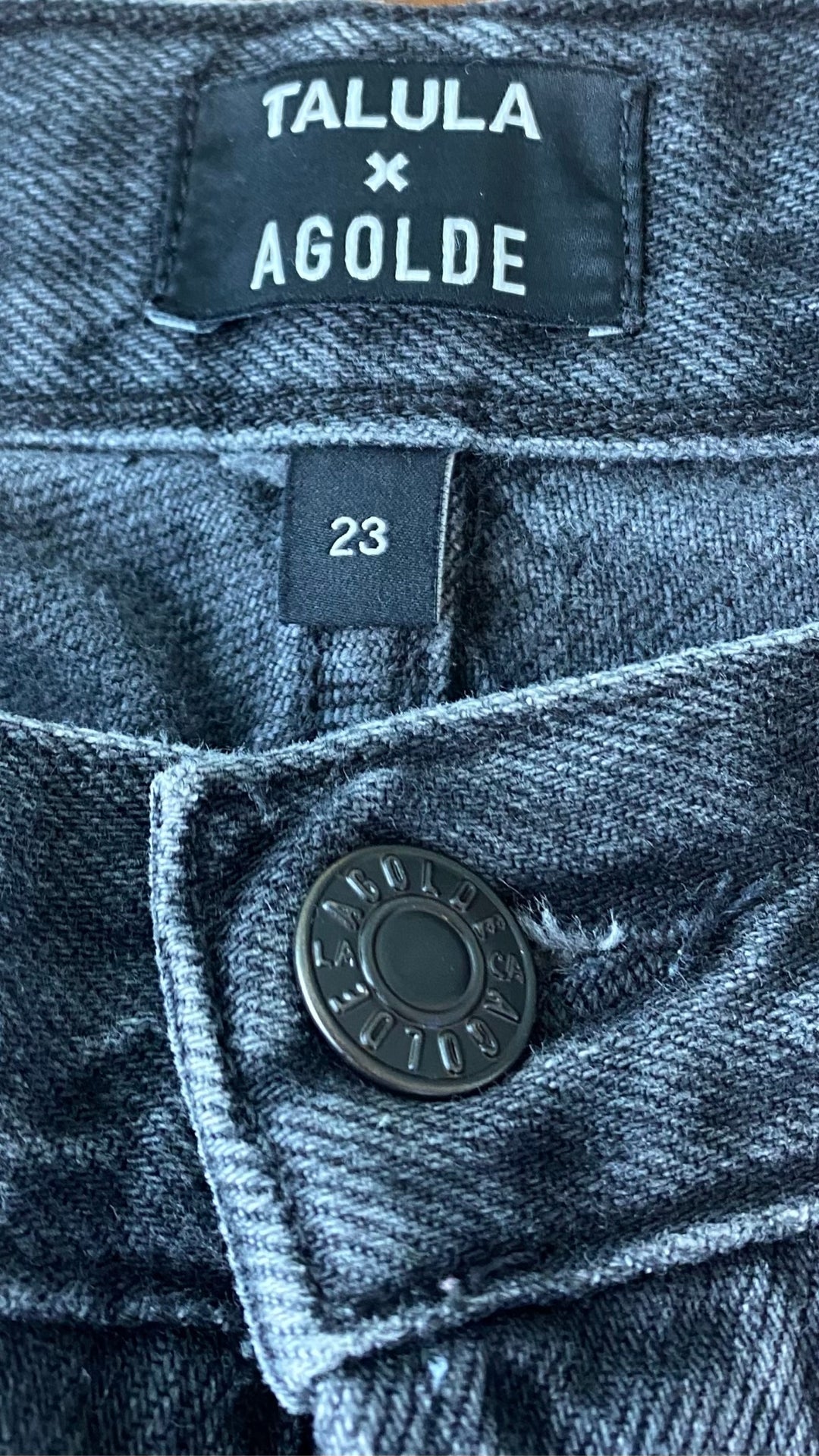 Jeans noir délavé à jambe étroite Agolde x Talula, taille 23. Vue de l'étiquette de marque et taille.