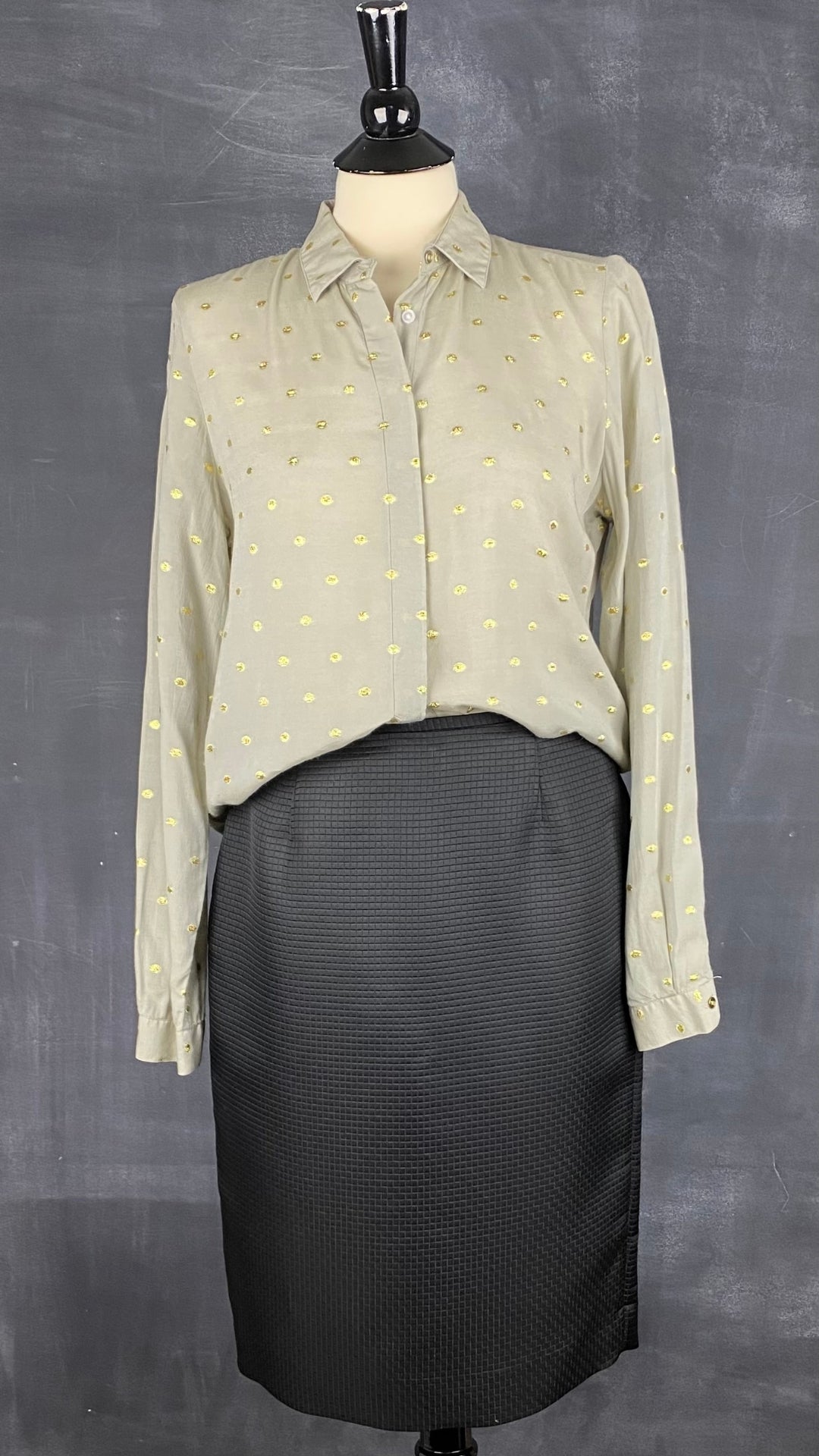 Jupe crayon noire texturée Calvin Klein, taille 6. Vue de l'agencement avec le chemisier en viscose à pois or.