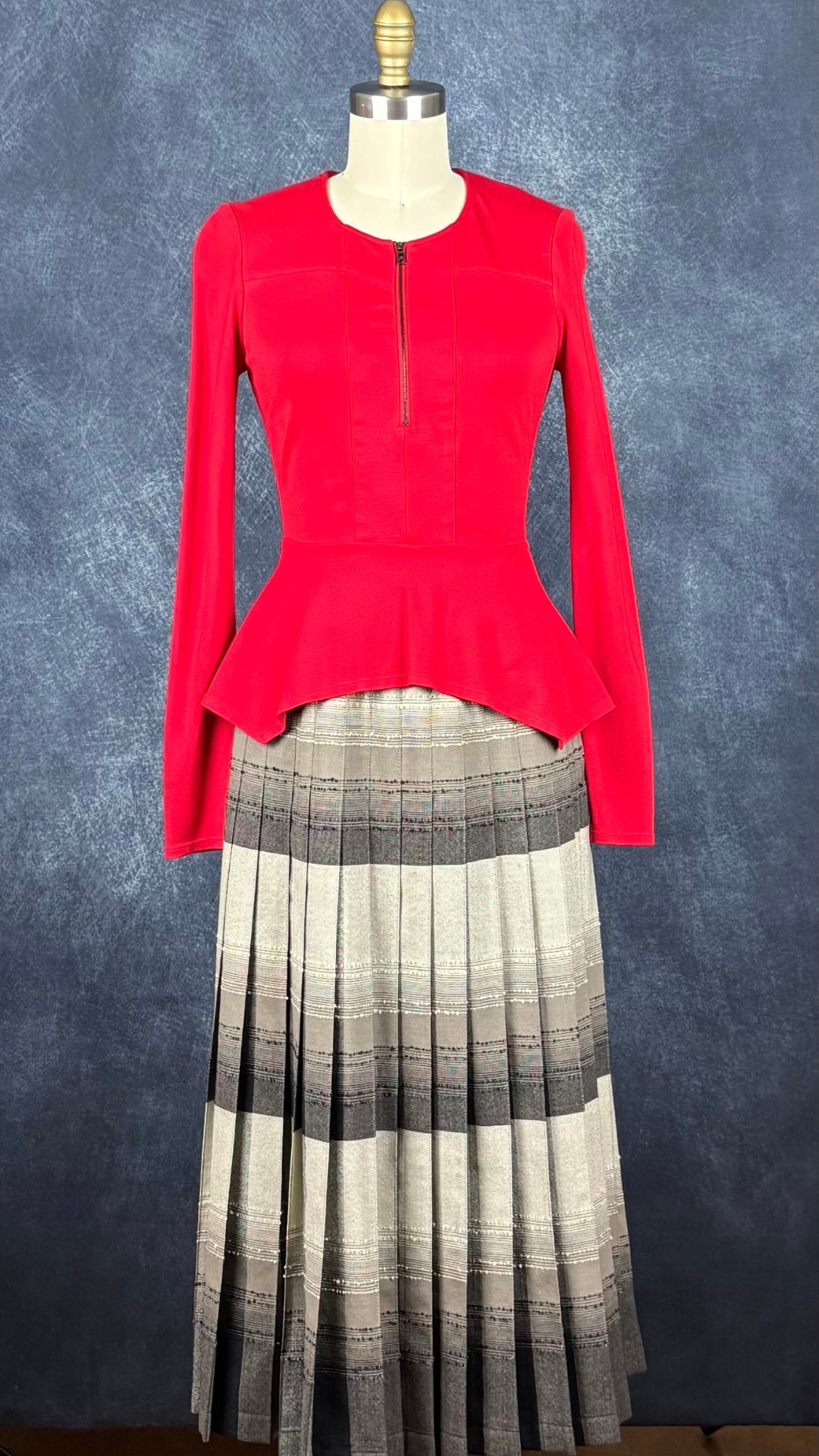 Jupe plissée vintage à carreaux réversible en laine Highland Queen, taille estimée à xs. Vue de l'agencement avec le chandail rouge BCBG avec ourlet asymétrique.