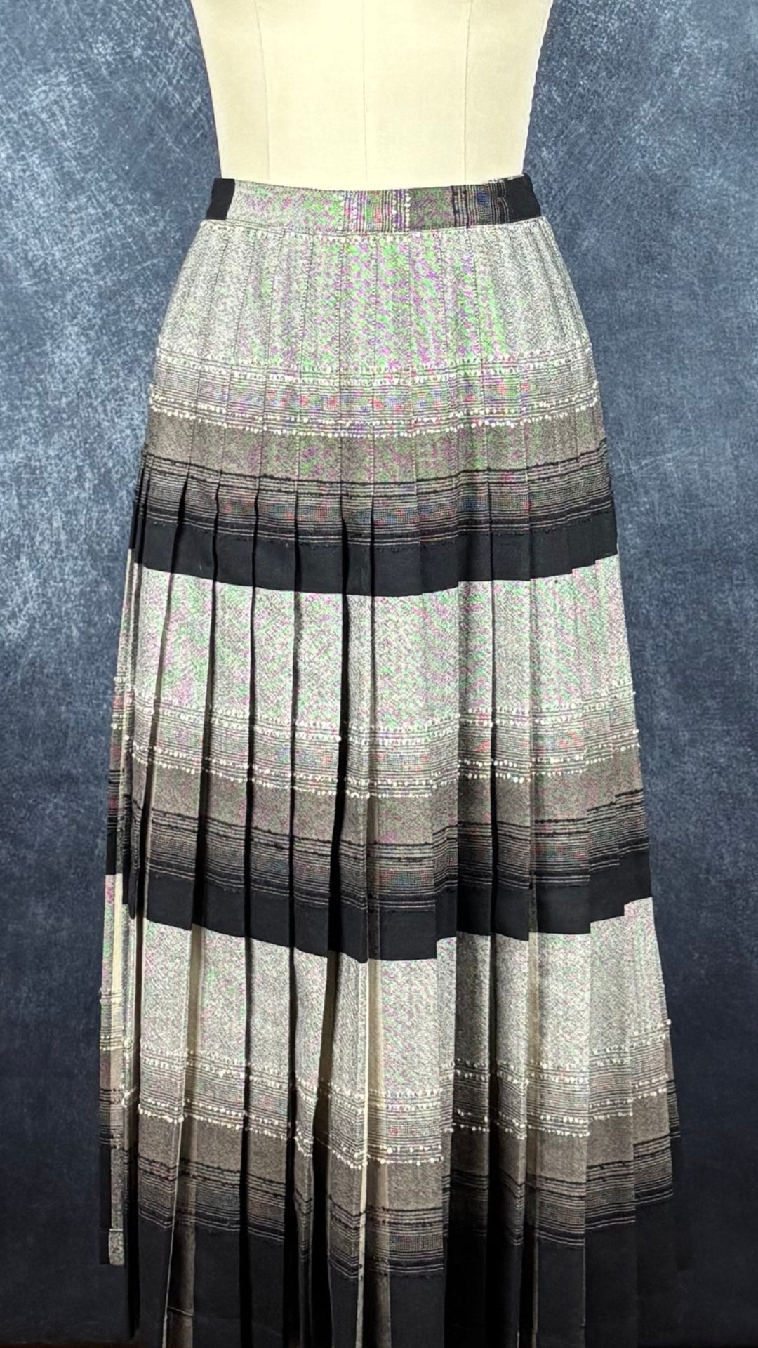 Jupe plissée vintage à carreaux réversible en laine Highland Queen, taille estimée à xs. Vue de la jupe sur le mannequin côté plus noir/gris.