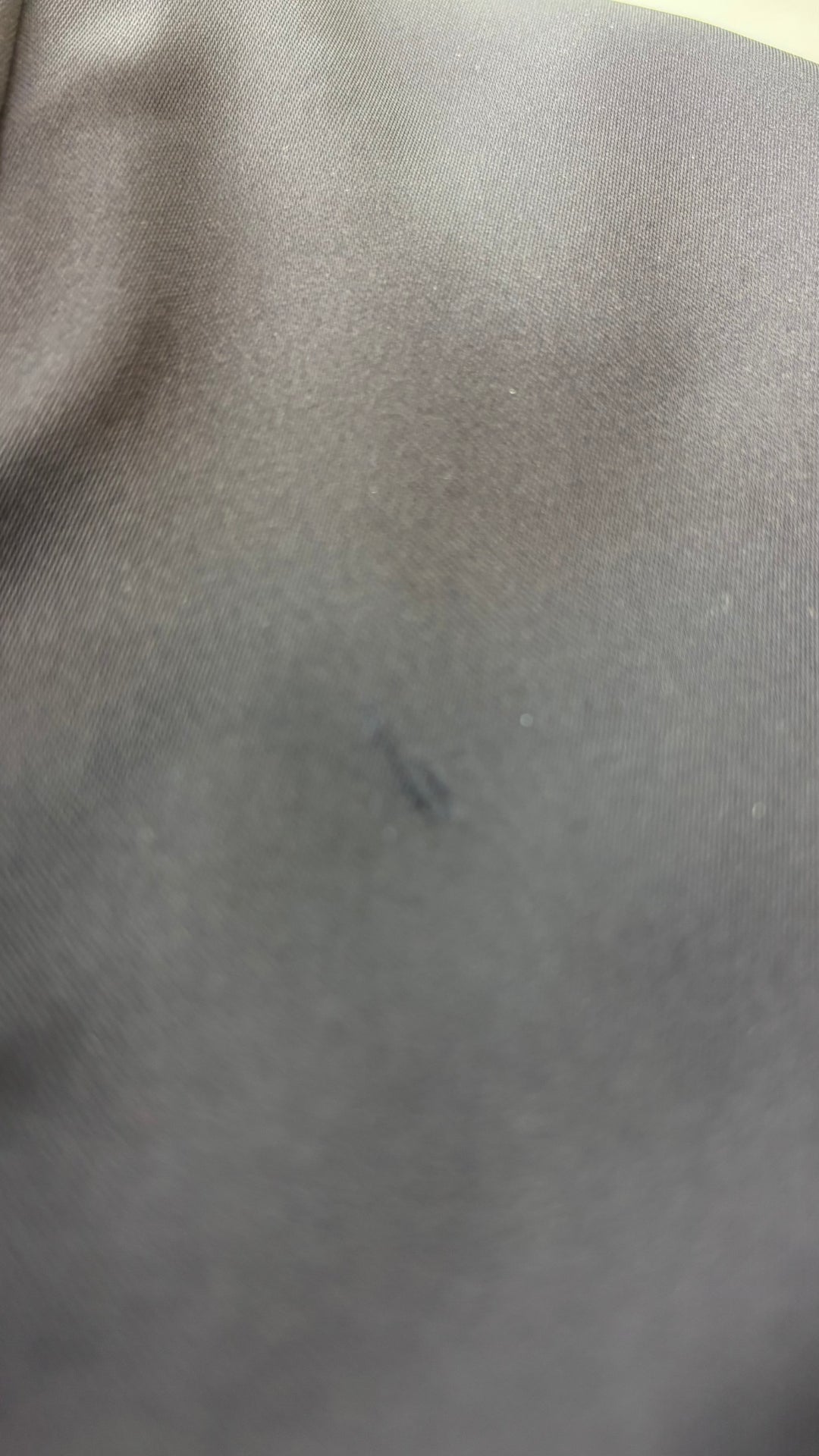 Jupe satinée noire Wilfred, taille 10. Vue de la petite marque, sous un angle où elle paraît plus, sans être très visible.