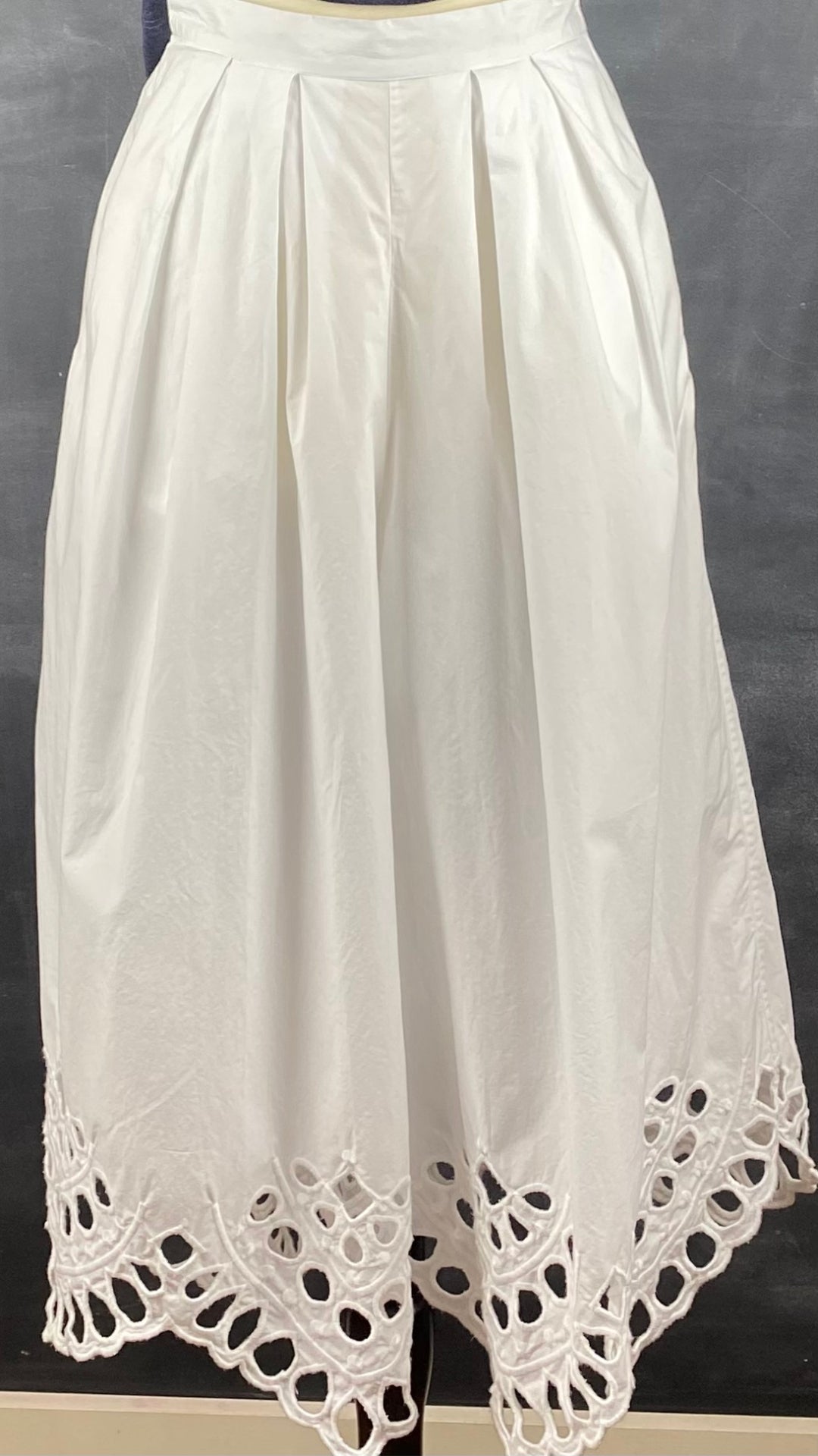 Pantalon très ample blanc style jupe avec broderie anglaise au bas des jambes. Marque French Connection, taille extra small, équivalent à 4. Vue de face.