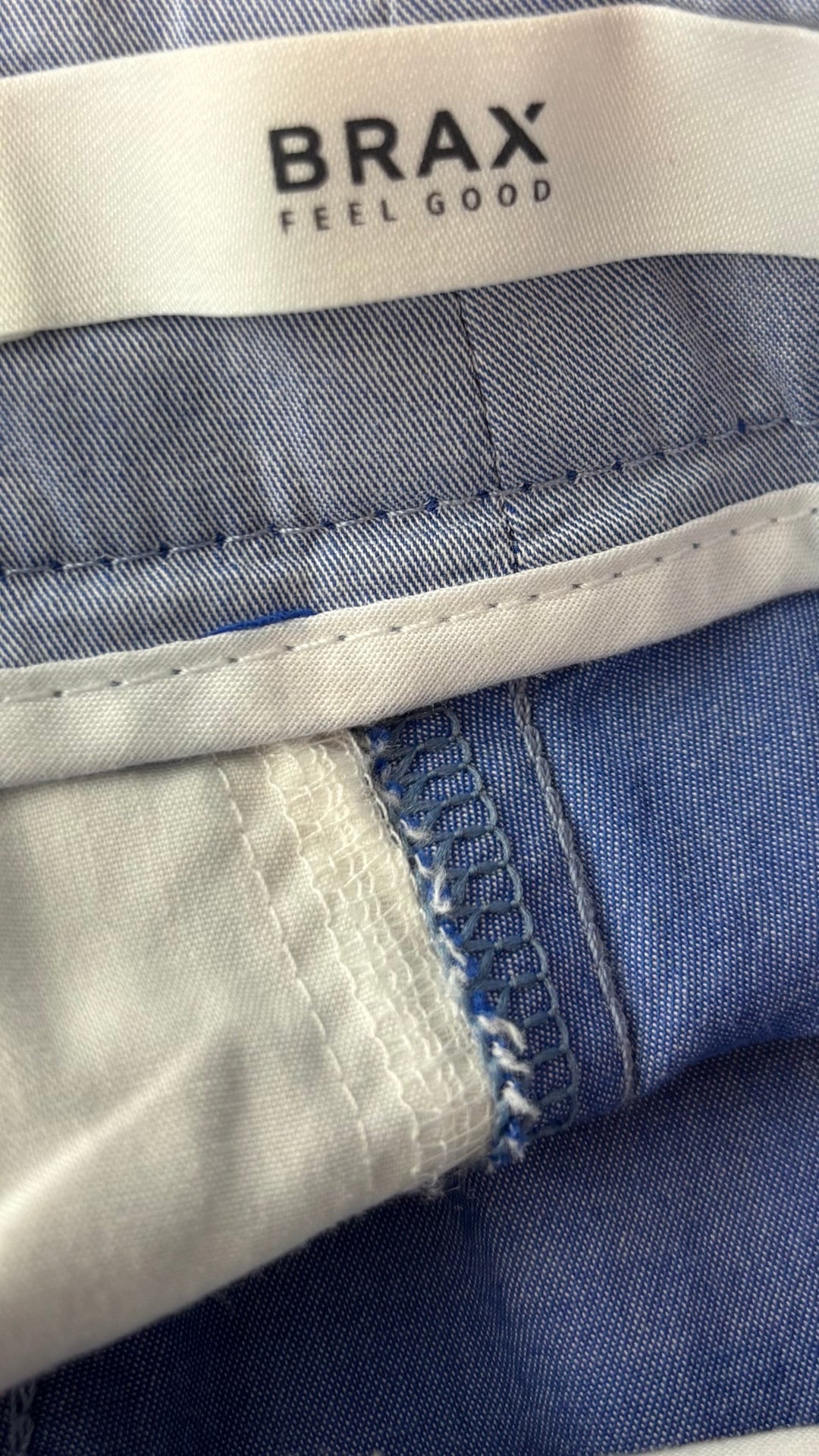 Pantalon bleu doux liséré bleu moyen sur le côté des jambes Brax, taille 27. Vue de l'étiquette.
