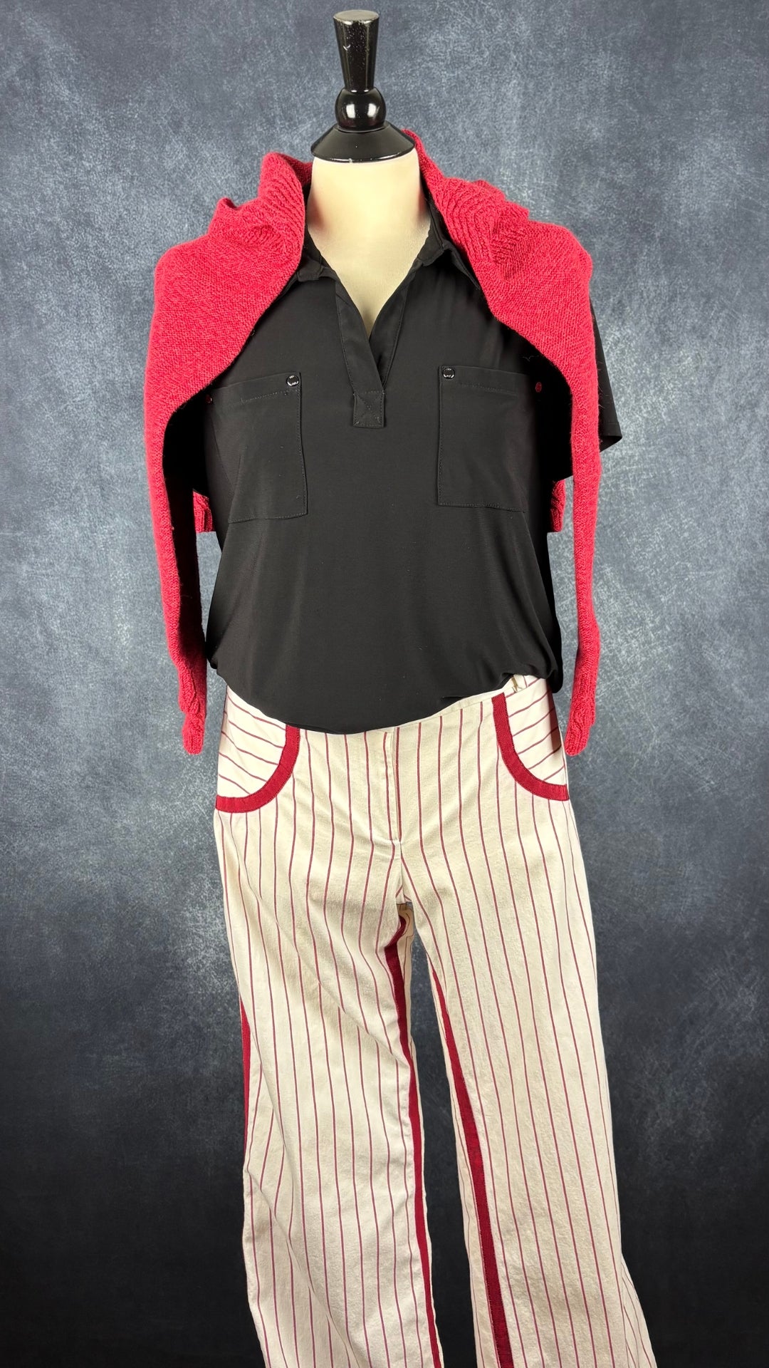 Pantalon crème à rayures rouges Andy The Anh Pow, taille 12. Vue de l'agencement avec le polo noir et un tricot rouge sur les épaules.