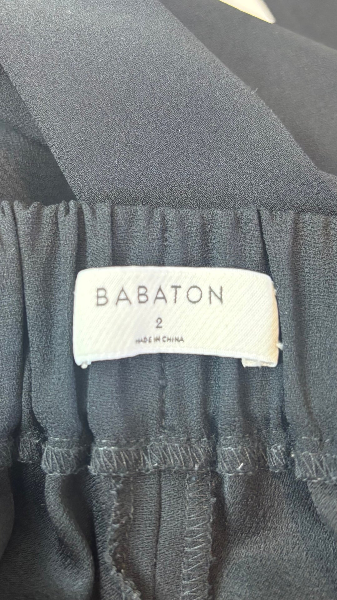 Pantalon noir court avec bandes lisérées crème sur les côtés Babaton, taille 2. Vue de l'étiquette.