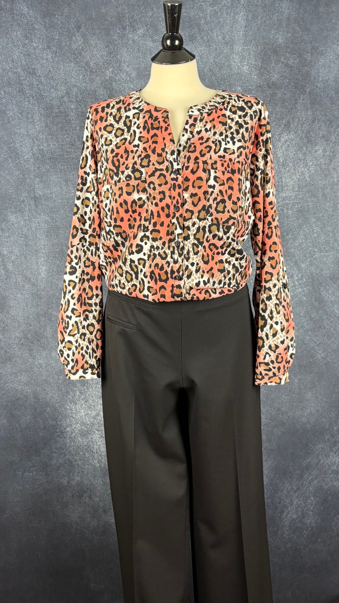 Pantalon noir jambe large à revers Sarah Pacini, taille estimée à large. Vue de l'agencement avec la blouse léopard colorée.