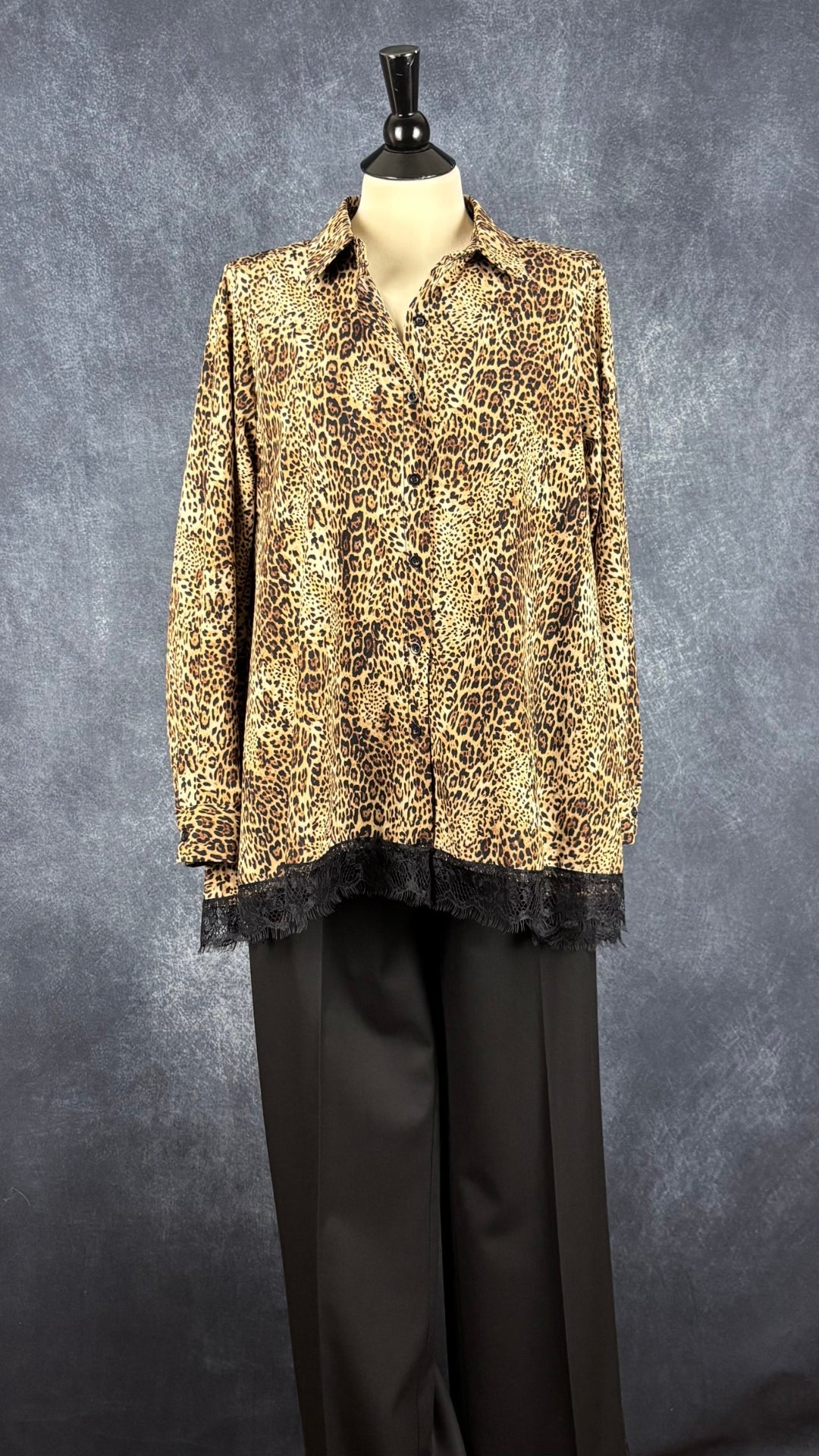 Pantalon noir jambe large à revers Sarah Pacini, taille estimée à large. Vue de l'agencement avec la blouse léopard à dentelle Uchuu.