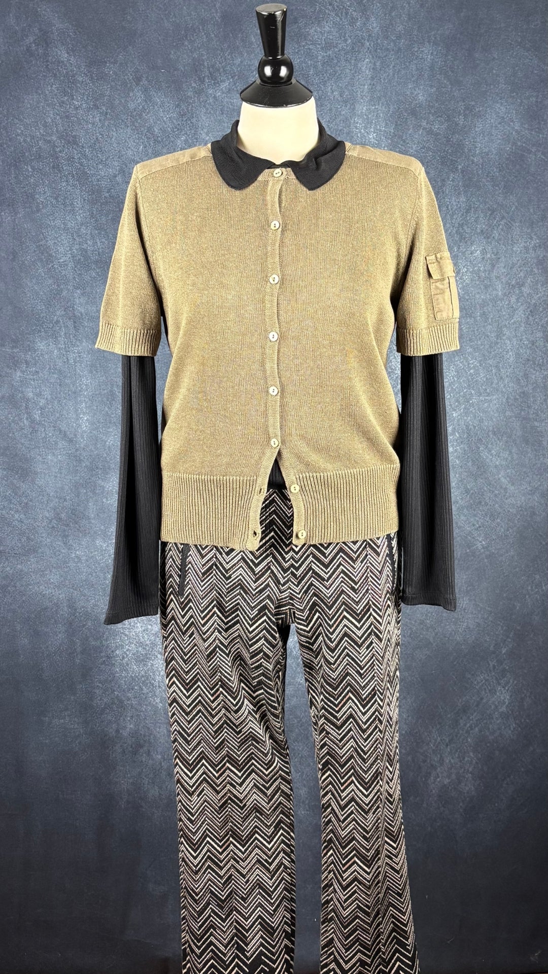 Pantalon à taille extensible à chevrons Cambio, taille 10. Vue de l'agencement avec le polo noir et le cardigan kaki Gardeur.