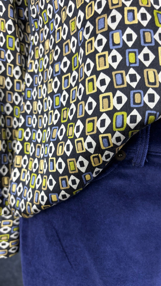 Pantalon en velours extensible bleu nuit Iris Setlakwe, taille 6. Vue de près de l'agencement avec le chemisier en soie à motifs.