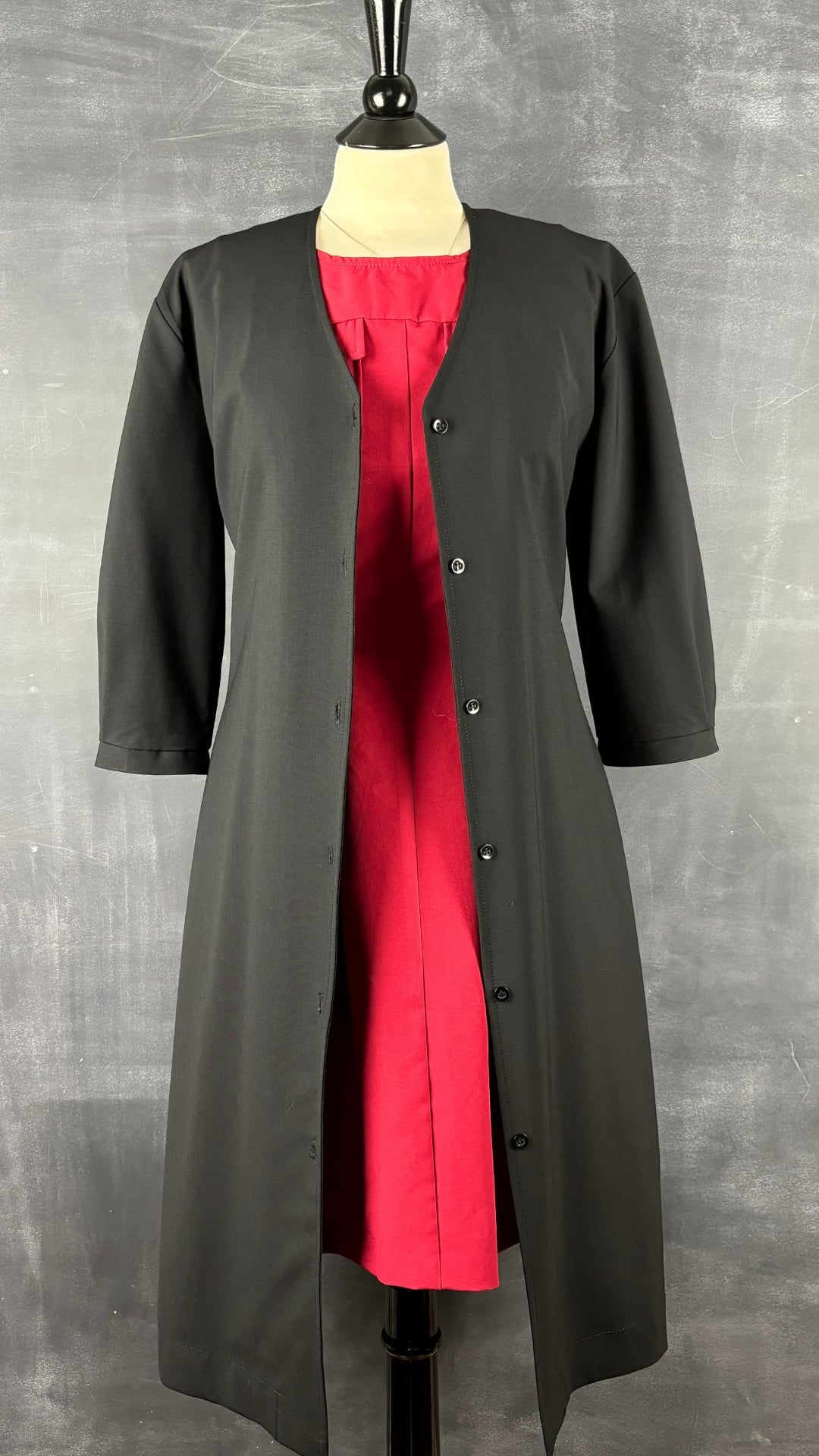 Robe boutonnée noire François Beauregard, taille small ample. Vue de l'agencement avec une robe rouge.