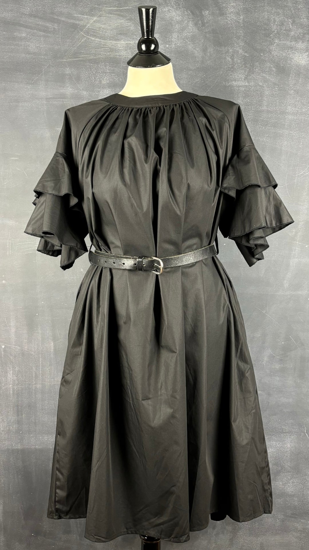 Robe noire ample manches à volants, taille one size. Vue de la robe, cintrée avec une ceinture.