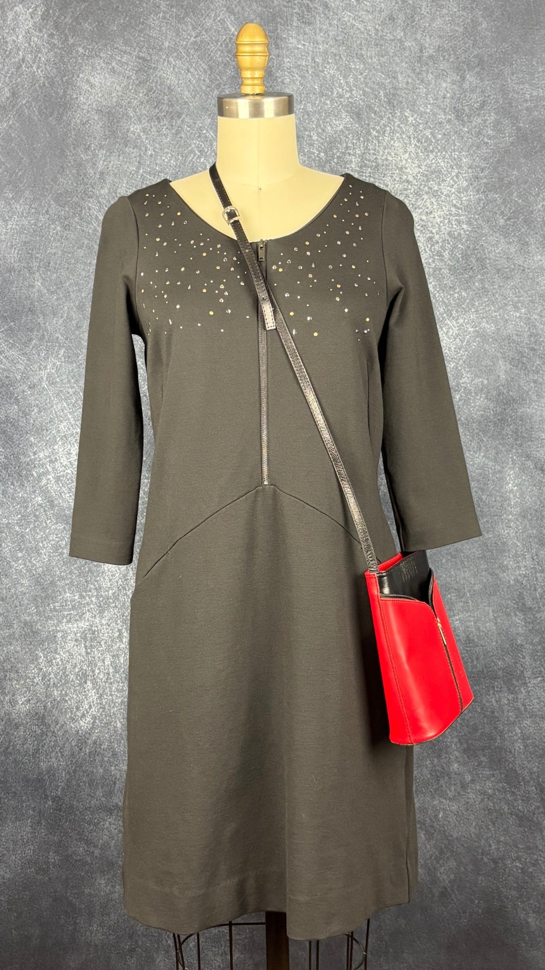 Robe noire confortable encolure cloutée Sandwich, taille small. Vue de face, agencée avec le sac à main en cuir rouge et noir.