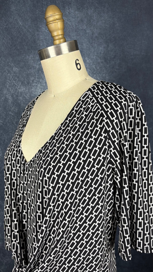 Robe noire à motifs géométriques écru, nouée à l'avant, Judy Judy Design, taille estimée à small/medium. Vue de l'encolure.