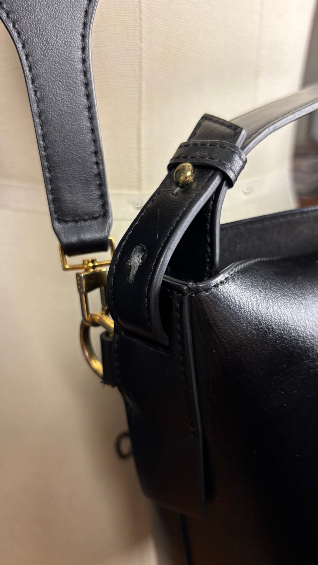 Sac sceau noir à poignée et bandoulière en cuir Want Les Essentiels. Vue de près du côté de la poignée.