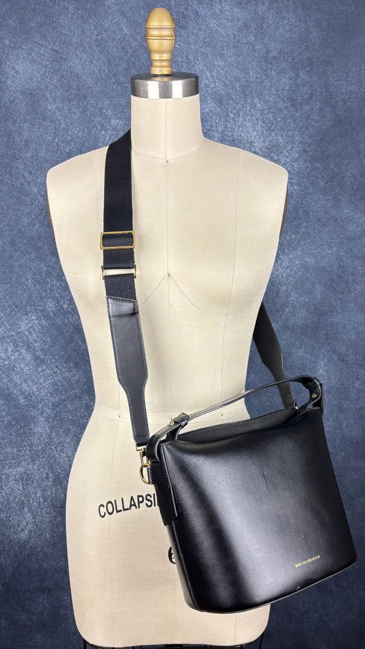 Sac sceau noir à poignée et bandoulière en cuir Want Les Essentiels. Vue de côté, sur le mannequin.