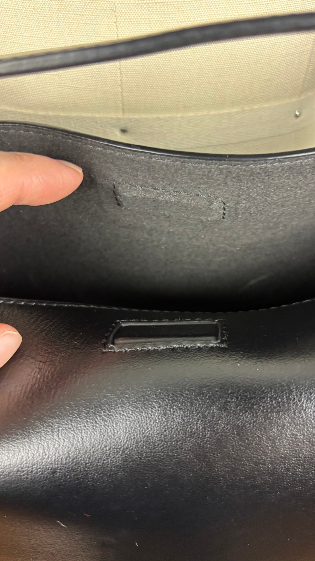 Sac sceau noir à poignée et bandoulière en cuir Want Les Essentiels. Vue de près du fermoir aimanté, ouvert.